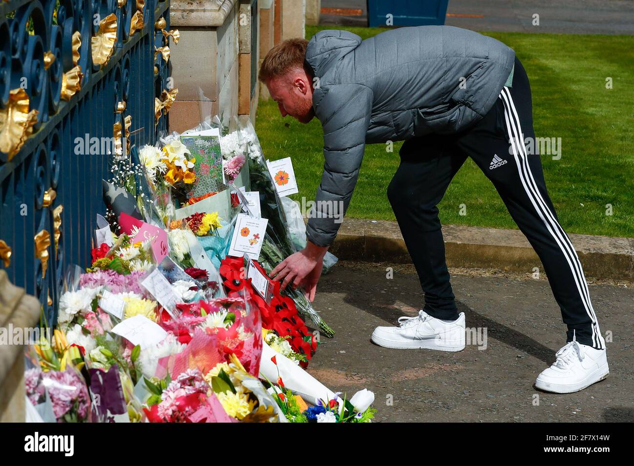 A man lays flowers in front of flowers placed at Hillsborough Castle after Britain's Prince Philip, husband of Queen Elizabeth, died at the age of 99, in Hillsborough, Northern Ireland, April 10, 2021. REUTERS/Jason Cairnduff Stock Photo