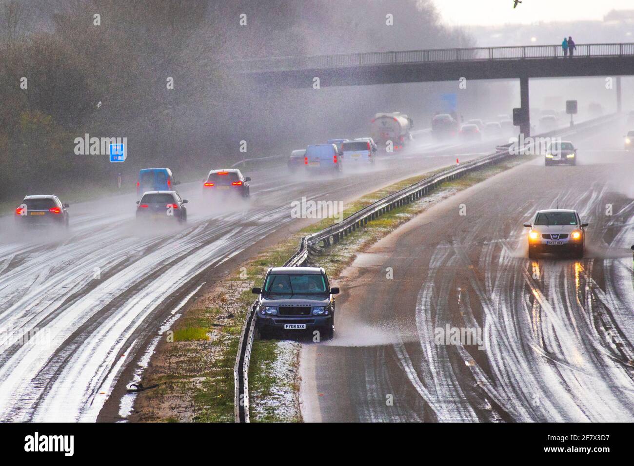 Motorway fast lane accident after driving in the middle of a hailstorm in hazardous driving conditions in Chorley Lancashire. April 2021 UK Weather;  Motorway mayhem as freak hail stone shower makes driving tricky with a series of collisions in Chorley. Car crashes into central reservation, 4 wheel drive vehicles in separate incidents collide with the armcor on the M61 central reservation. Stock Photo
