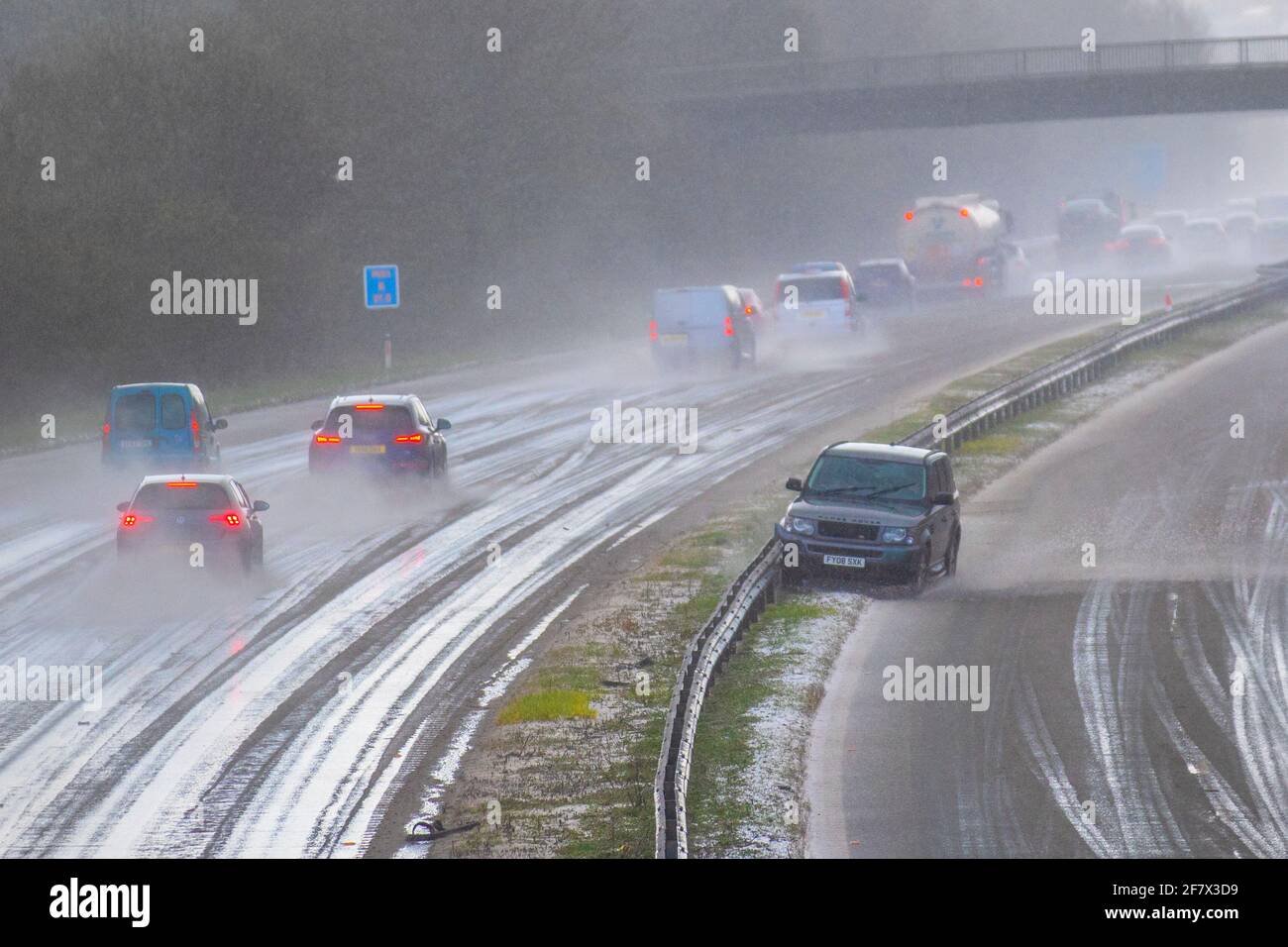 Motorway accident after driving in the middle of a hailstorm in hazardous driving  conditions in Chorley Lancashire. April 2021 UK Weather;  Motorway mayhem as freak hail stone shower makes driving tricky with a series of collisions in Chorley. Car crashes into central reservation, 4 wheel drive vehicles in separate incidents collide with the armcor on the M61 central reservation. Credit MediaWorldImages/AlamyLivenews Stock Photo