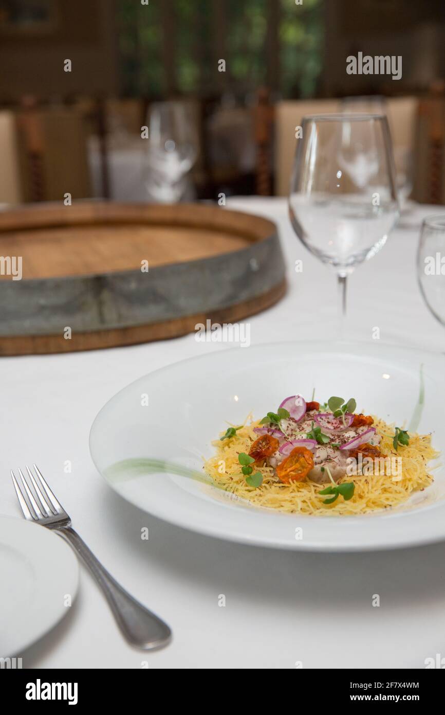 Delicious italian pasta dish served on a white cloth table in a fancy restaurant Stock Photo