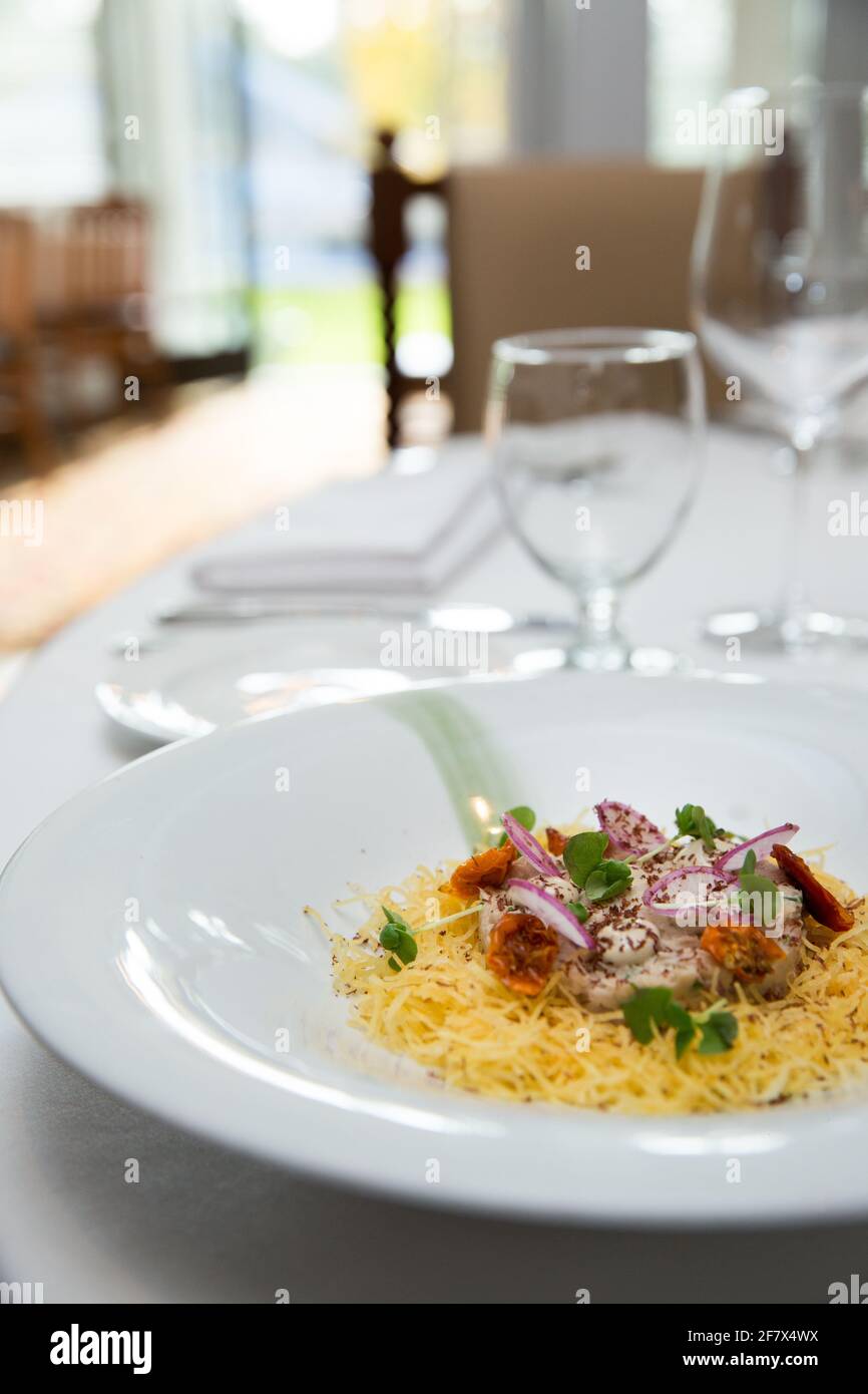 Delicious italian pasta dish served on a white cloth table in a fancy restaurant Stock Photo