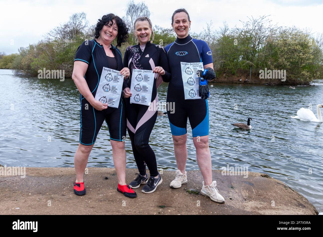 Northampton, UK. 10th April 2021. Shirley Payne Mann with support from Denise Anderson and Penny Etheridge (left to right) are wild swimming in freezing water of a lake for as long as they possible can raising money for Great Ormond Street Hospital. Credit: Keith J Smith./Alamy Live News Stock Photo