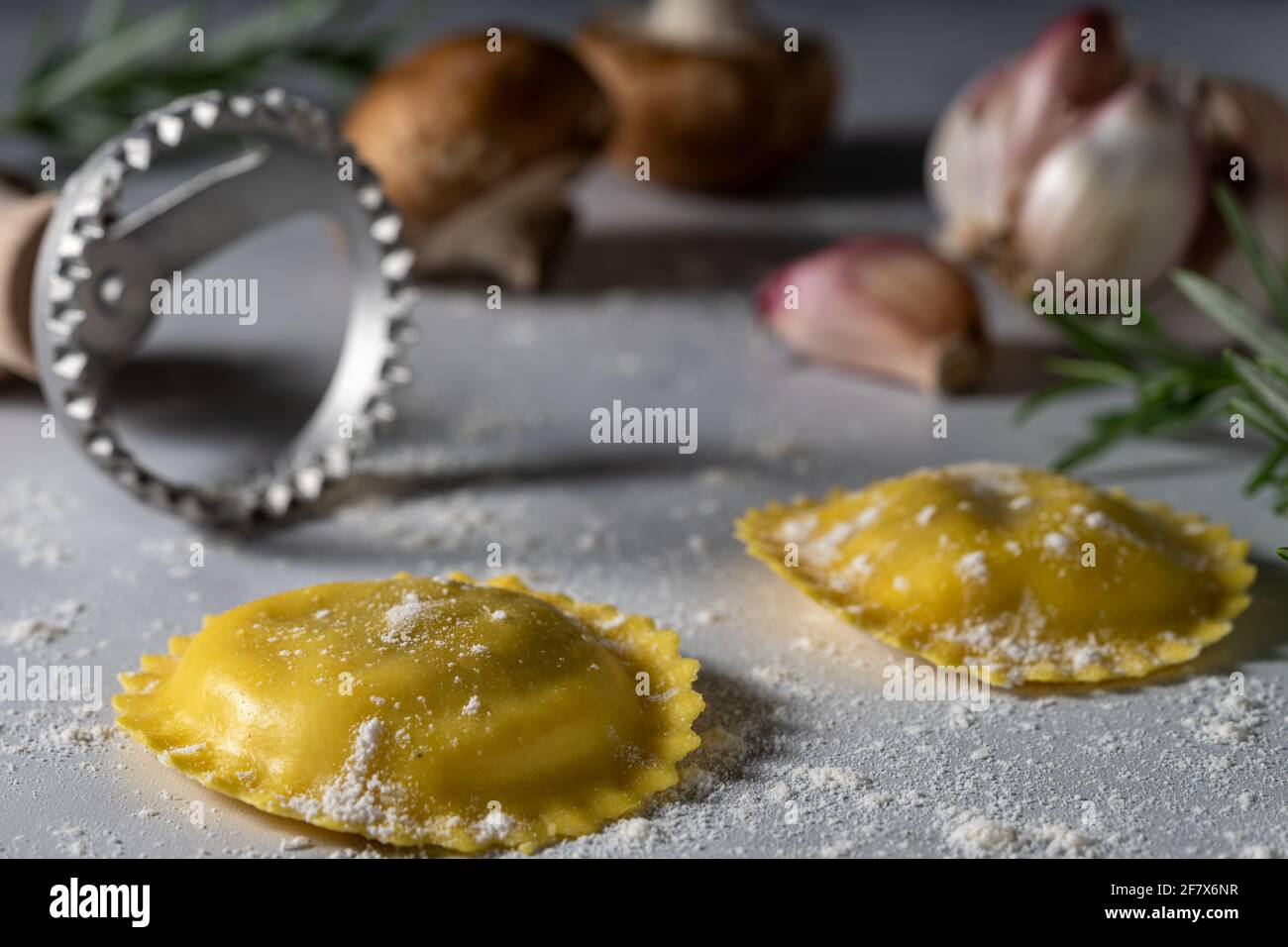 Mushroom stuffed ravioli and raw ingredients. Stock Photo