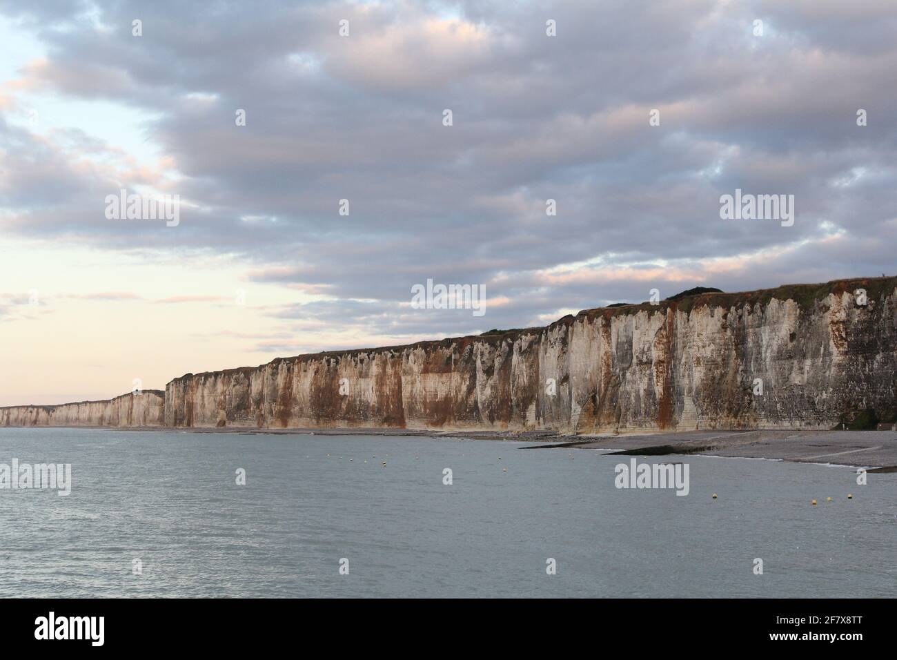 the white cliffs of the alabaster coast in saint-valery-en-caux in normandy with high tide and clouds Stock Photo