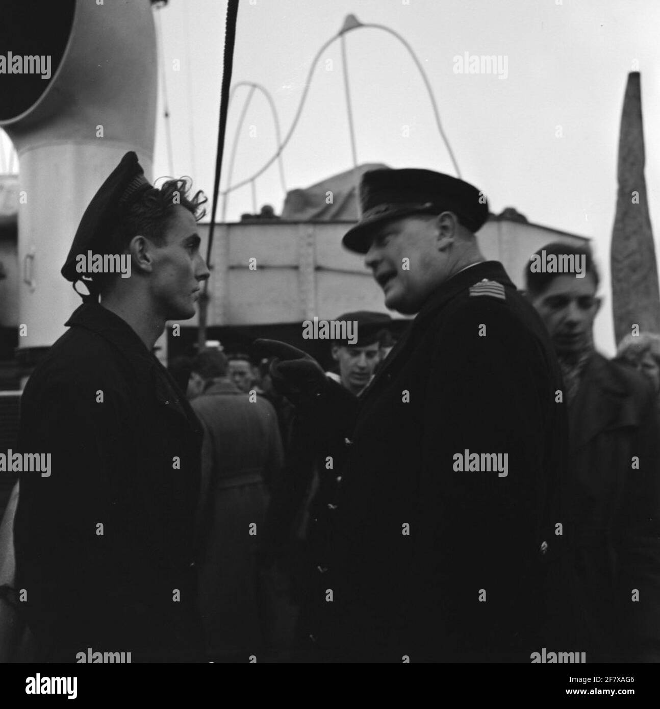 Return from the Korean waters of HR. Ms. Johan Maurits van Nassau (1943-1958) at the Africa Pier van de Coenhaven in Amsterdam. HEAD FLAOTALMOESIER MGR J.F.M. The SAIN speaks with one of the crew members. Is part of object series AVDKM 540054 to 540063. Stock Photo