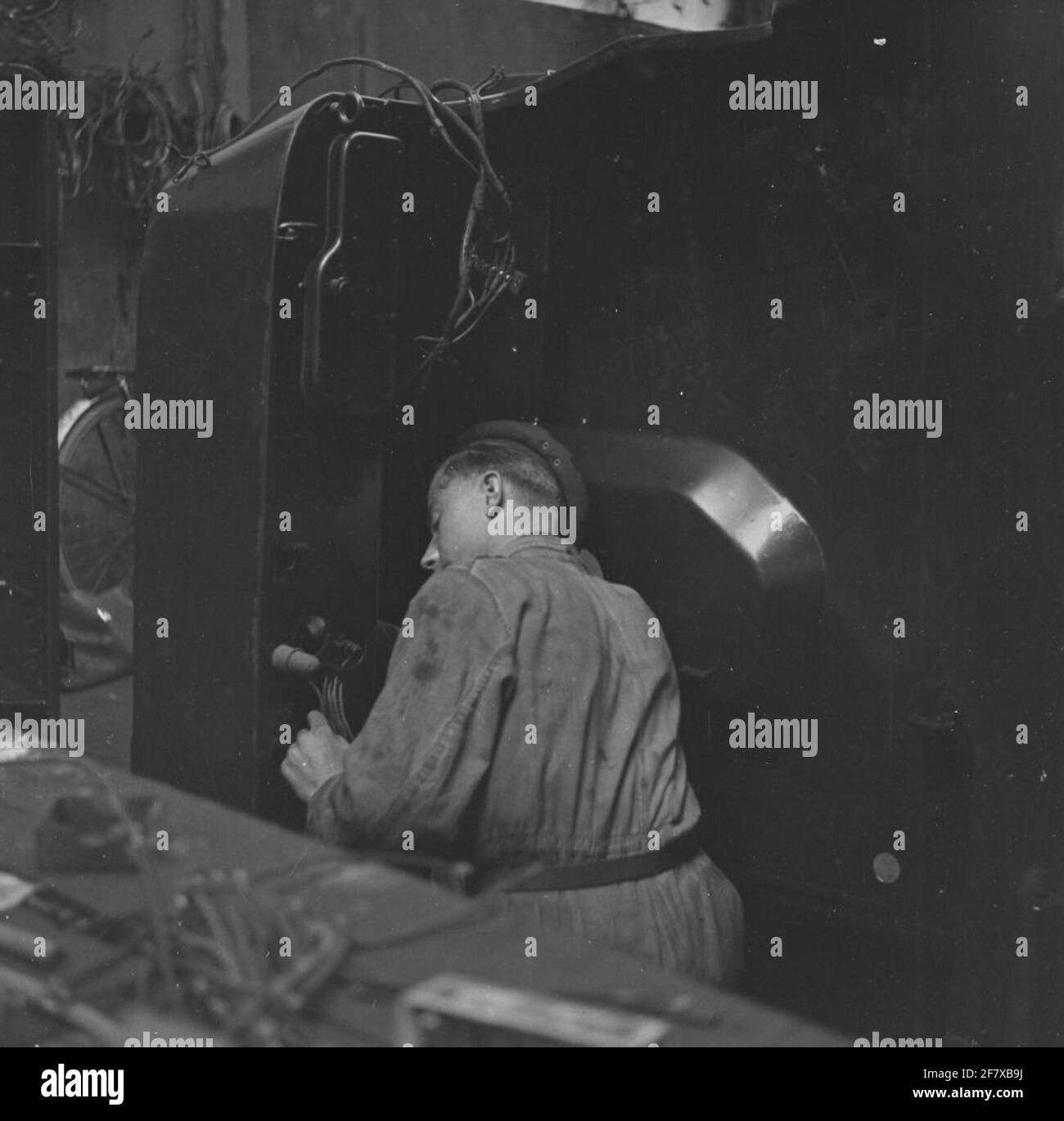 Mechanic engaged in the bodywork of a military vehicle. Underproof ...