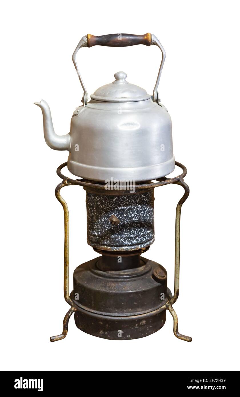 old aluminum teapot on a kerosene stove isolated on white background Stock Photo