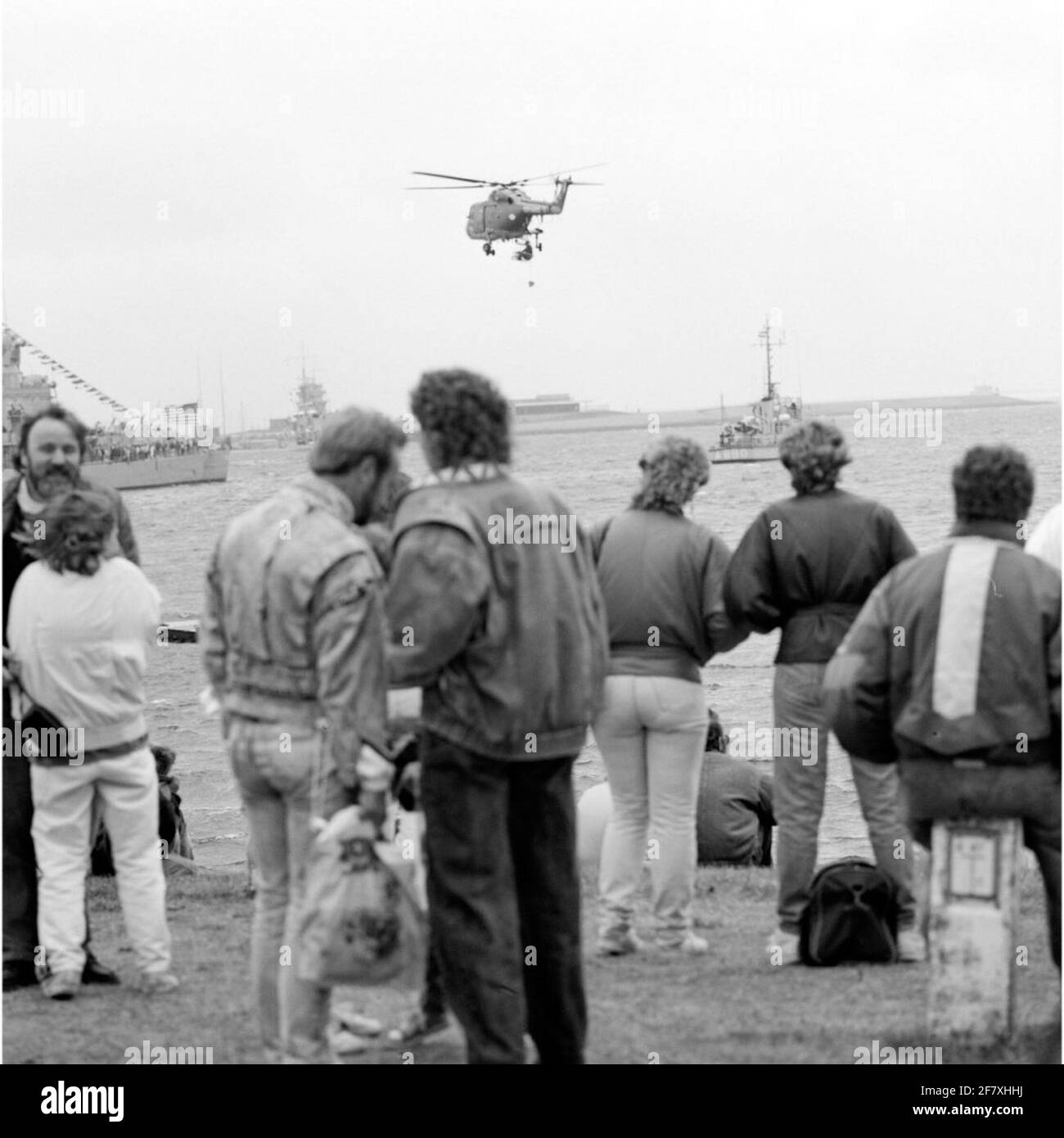 Interested parties during the fleet days in July 1989 watching a Westland SH-14D Navy Lynx Helicopter (1976-approx. 2012) of the Marine Air Carring Service (MLD), which a person from the water hoists m.b.v. A winch to which a Z.G. Sling is attached.Rechts the patrol / training vessel Hr.Ms. Bulgia (A 880). Stock Photo