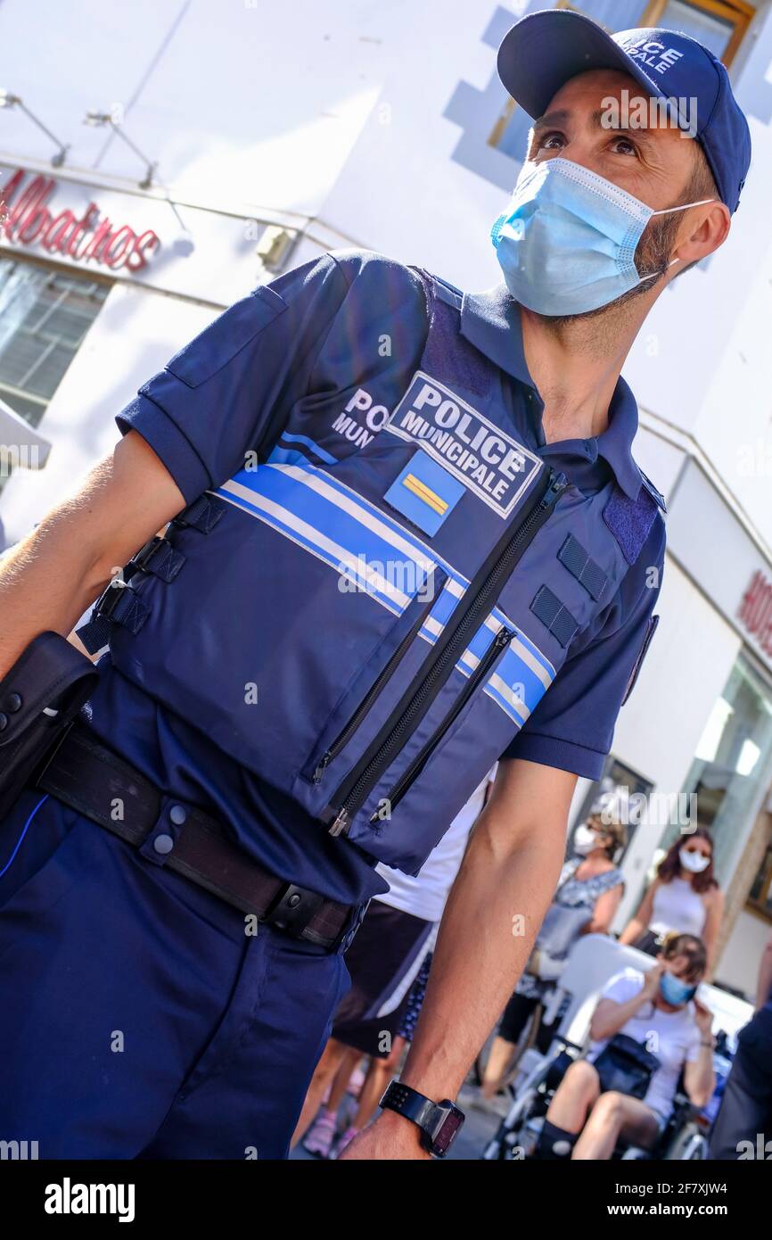 Frankreich, Le Pouliguen, 12.07.2020: ein Vertreter der staedtischen Polizei mit Maske regelt an einem Markttag den Zugang zum Markt und ueberwacht di Stock Photo