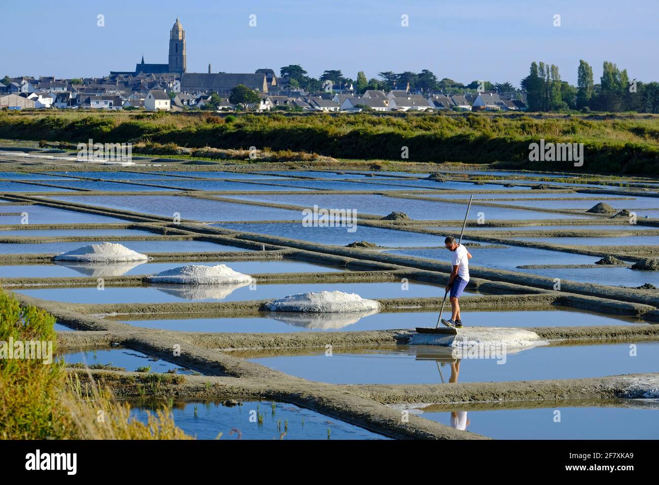 Frankreich, Batz-sur-Mer, 15.07.2019: Salzproduzent bei der Arbeit im Marais Salants bei Batz-sur-Mer, wo Salz aus Meerwasser durch Verdunstung gewonn Stock Photo