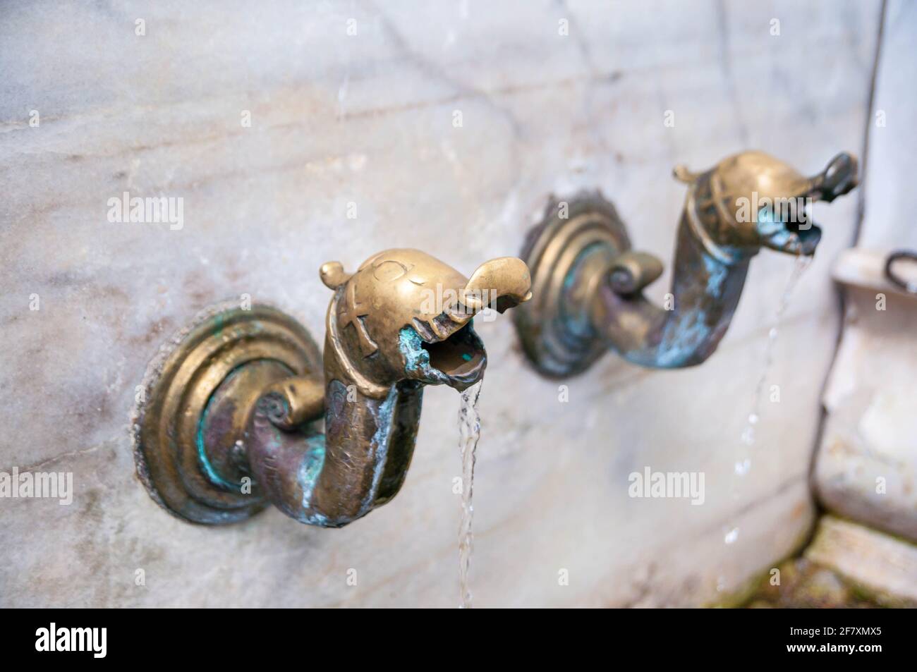 Brass water taps on a marble wall in Bachkovo Monastery - an Orthodox Christian Monastery in Bulgaria Stock Photo