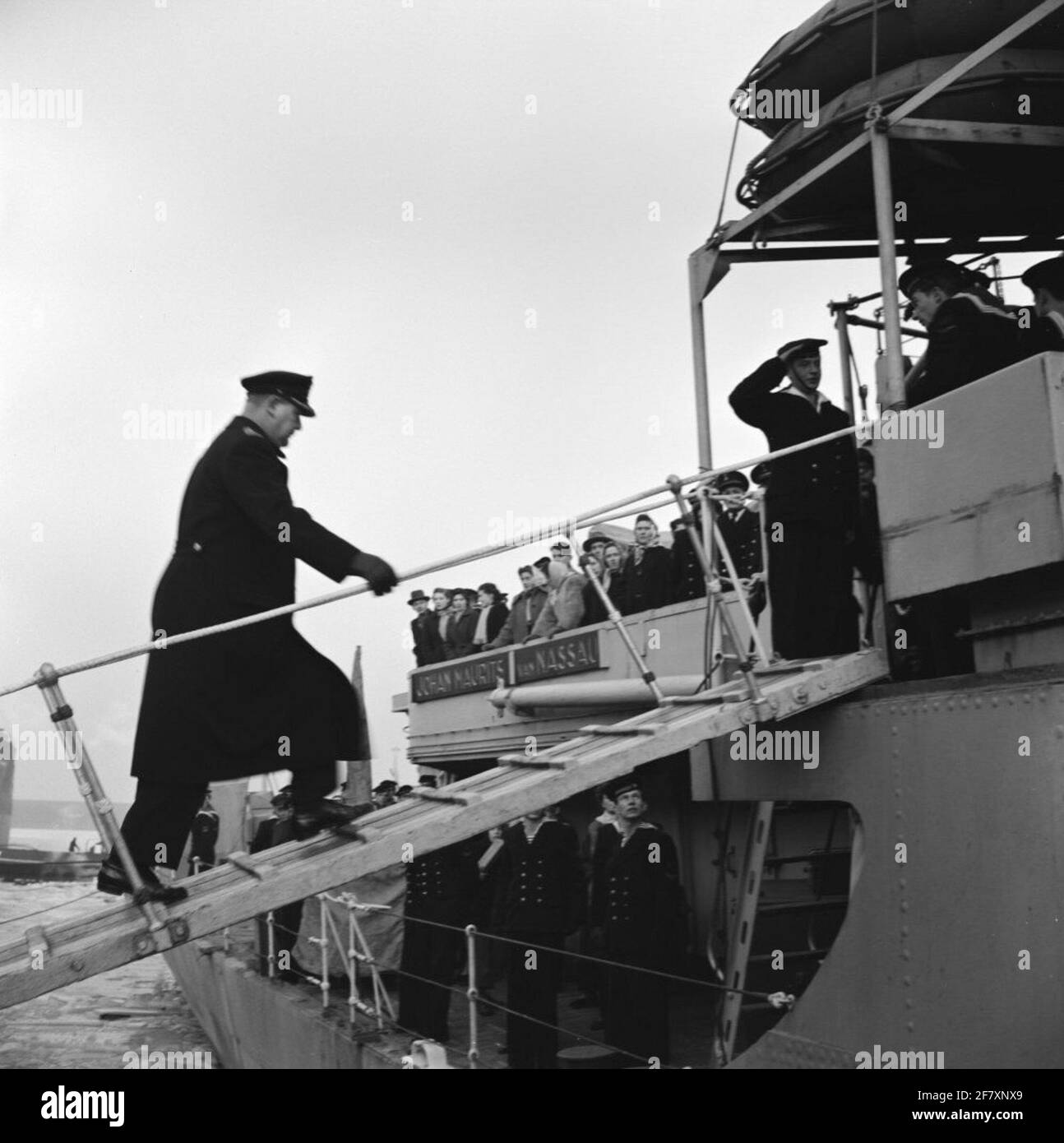 Return from the Korean waters of HR. Ms. Johan Maurits van Nassau (1943-1958) at the Africa Pier van de Coenhaven in Amsterdam. HEAD FLAOTALMOESIER MGR J.F.M. The SAIN goes on board to greet the crew. Is part of object series AVDKM 540054 to 540063. Stock Photo
