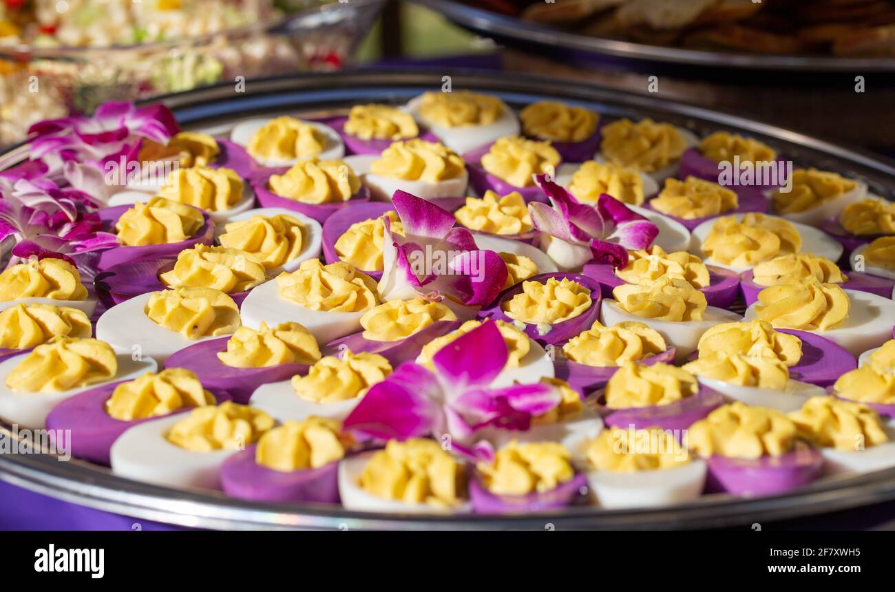 white and purple deviled eggs served on a plate at a party Stock Photo