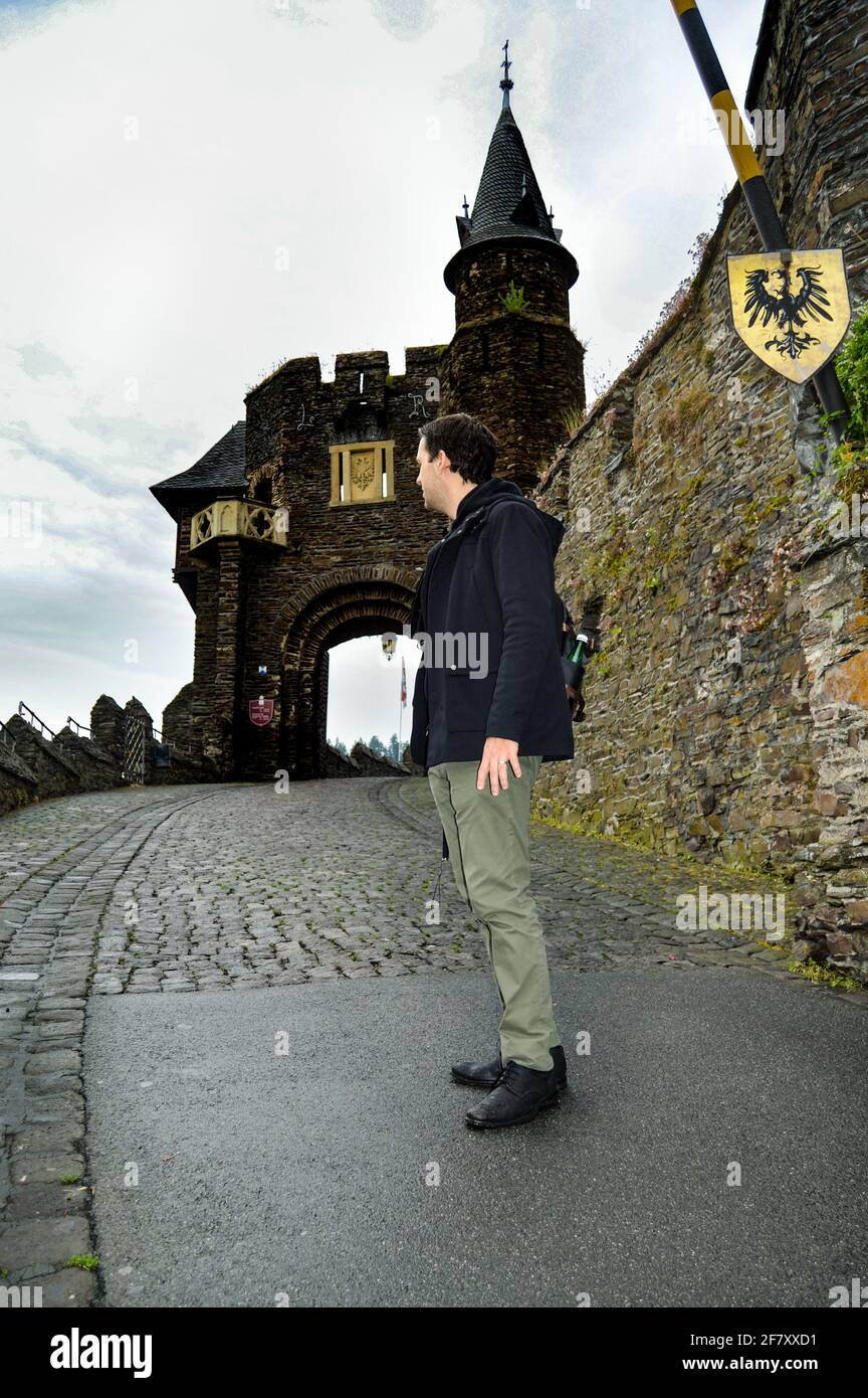 Man standing near the castle with gothic revival architecture in ...