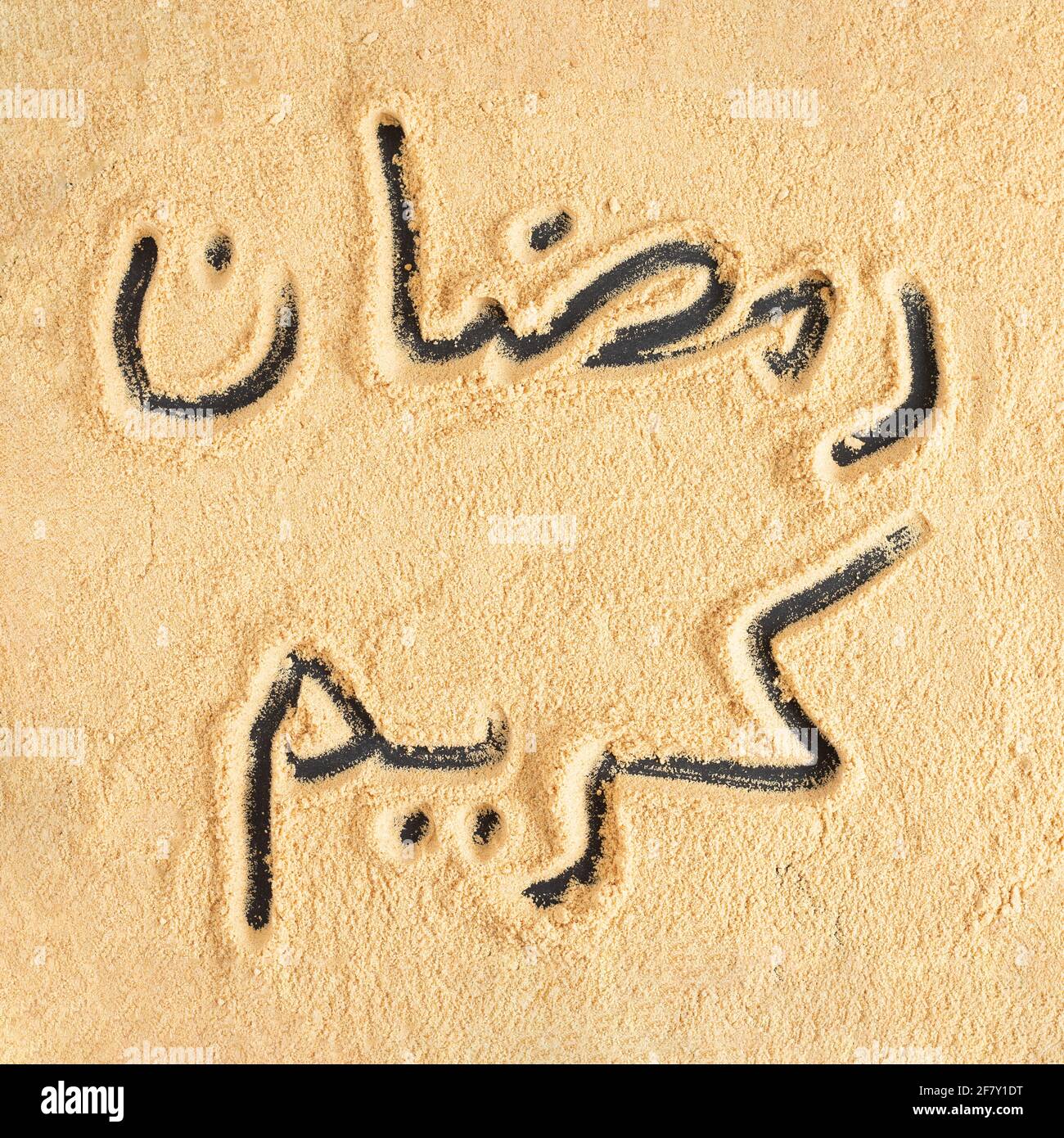 Top view of Arabic words drawn into soft brown sand Stock Photo - Alamy