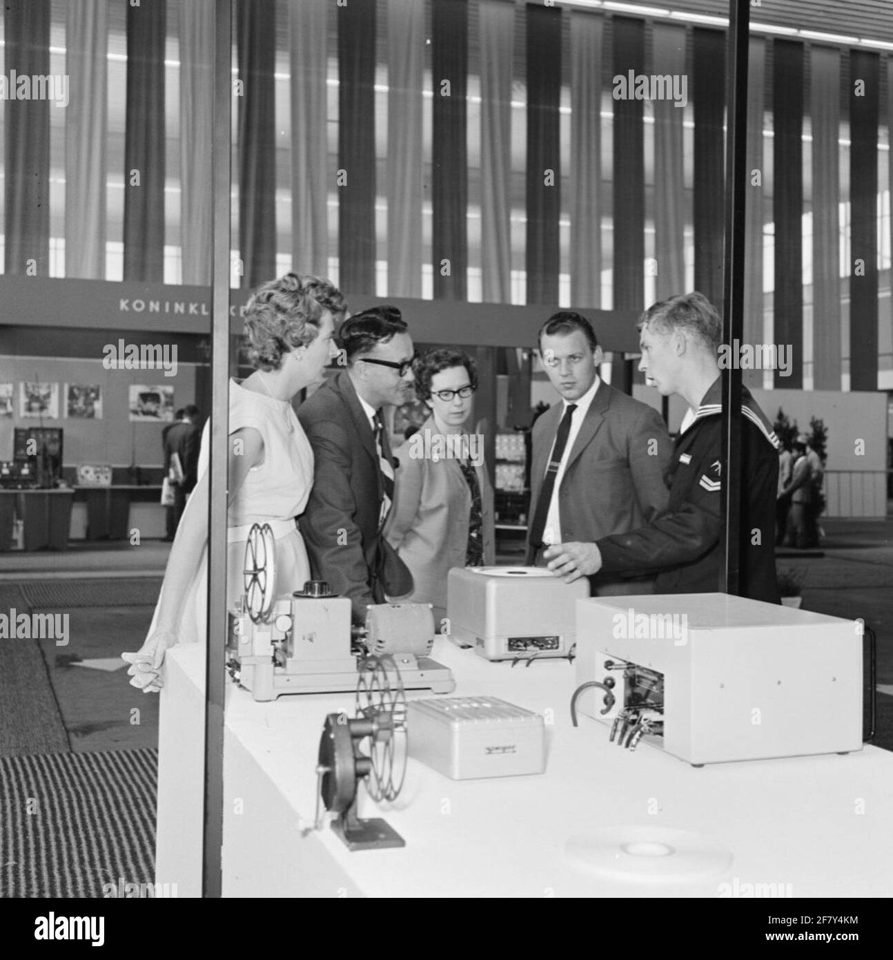Interested visitors in the Marine Stand on the Firato in the RAI building in Amsterdam listen to the explanation of a corporal telegraphist (Kpltlg). The Firato is an exhibition / exhibition for audio and video equipment, but Defense usually had recruitment stands. Stock Photo