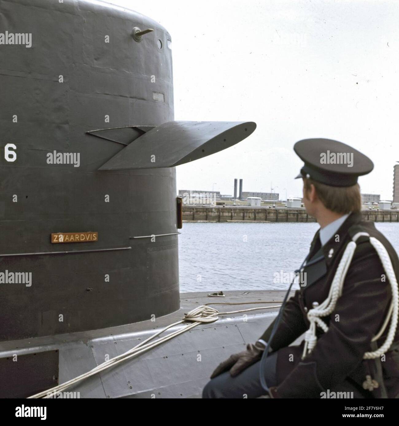 The Could. Marechaussee during inspection on the scaffolding of the submarine service in the port of Den Helder with in the background the submarine Hr.Ms. Swordfish (1972-1994). Stock Photo