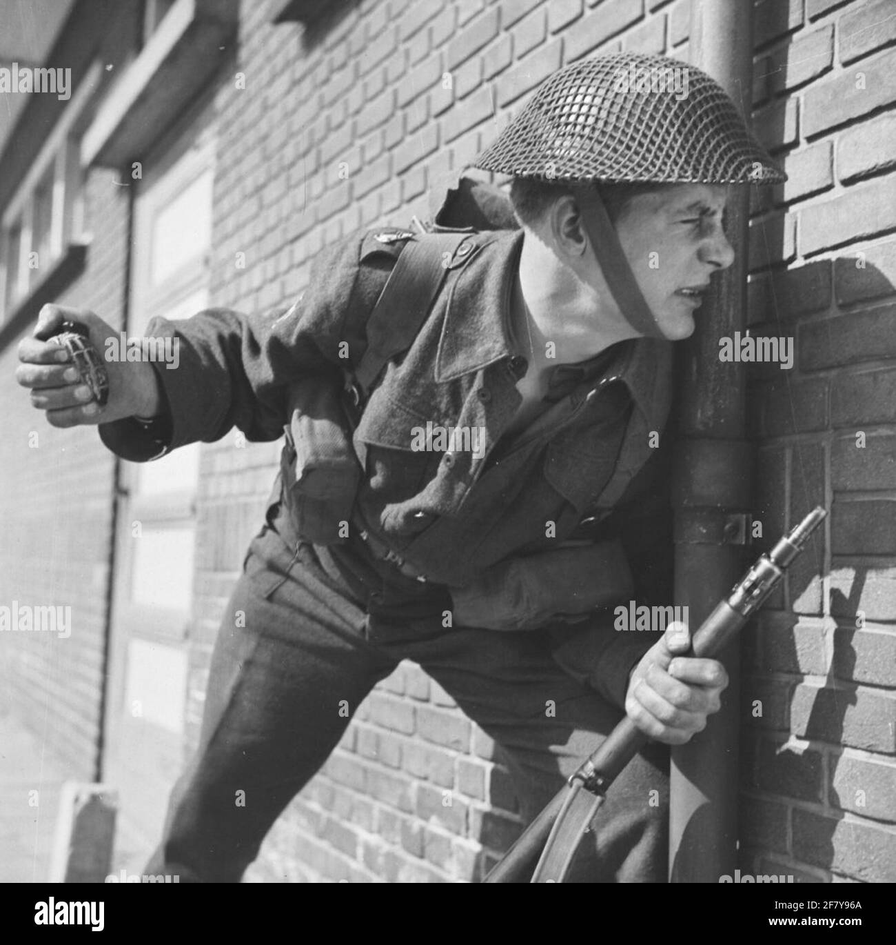 An infanterist ready to throw a practice hand grenade. Normally these are white in color. Here the white is almost finished. Stock Photo
