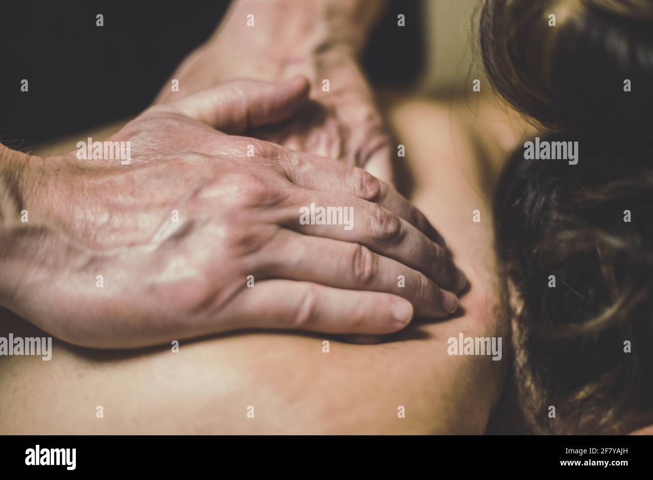 Soft focus view of man massaging a woman in a wellness center Oiled hands on a body relaxing the muscles and relieve tension   Holistic exercise Stock Photo