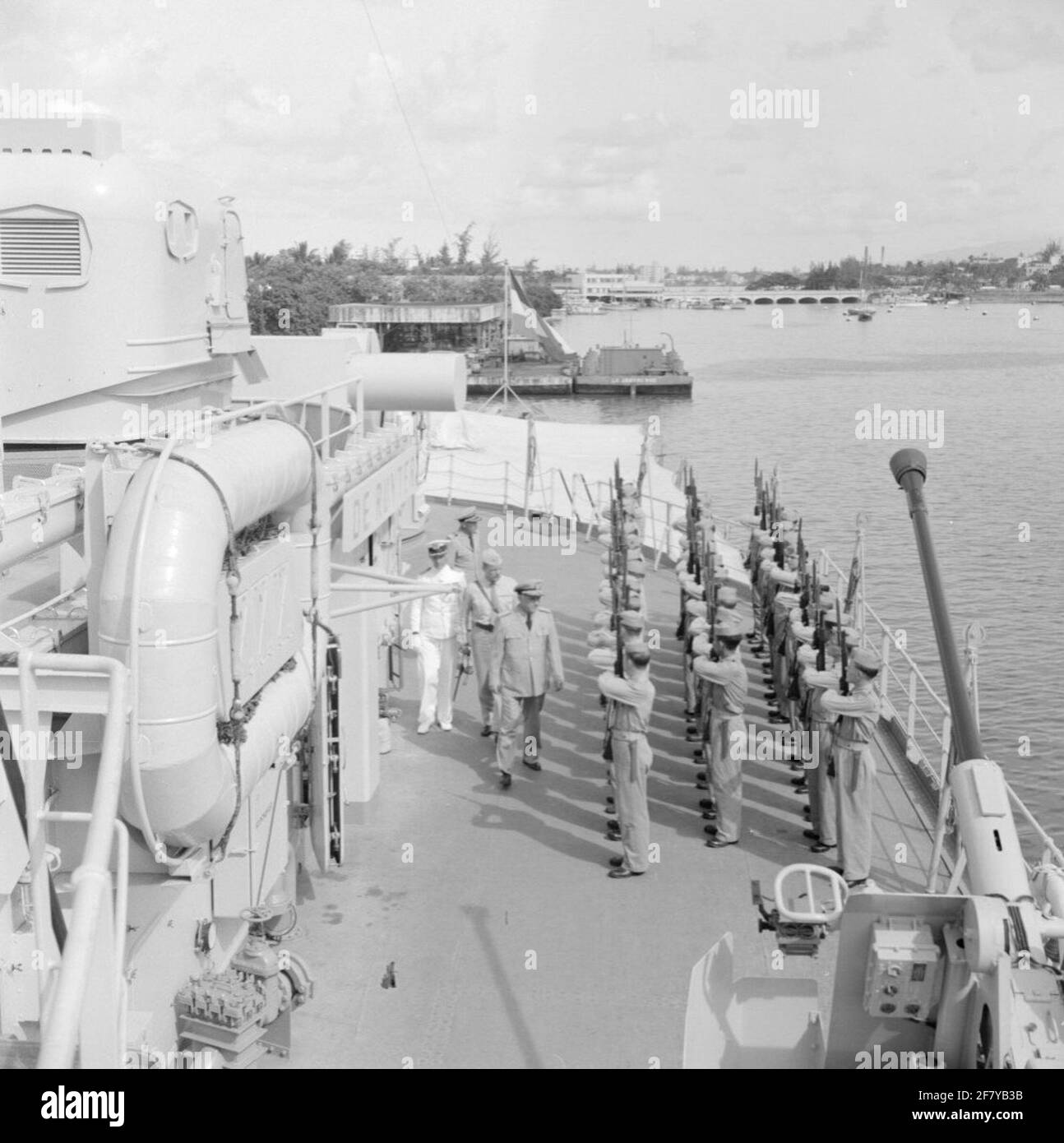 An American admiral (center front in khaki uniform) inspects the armed guard on board cruiser Hr