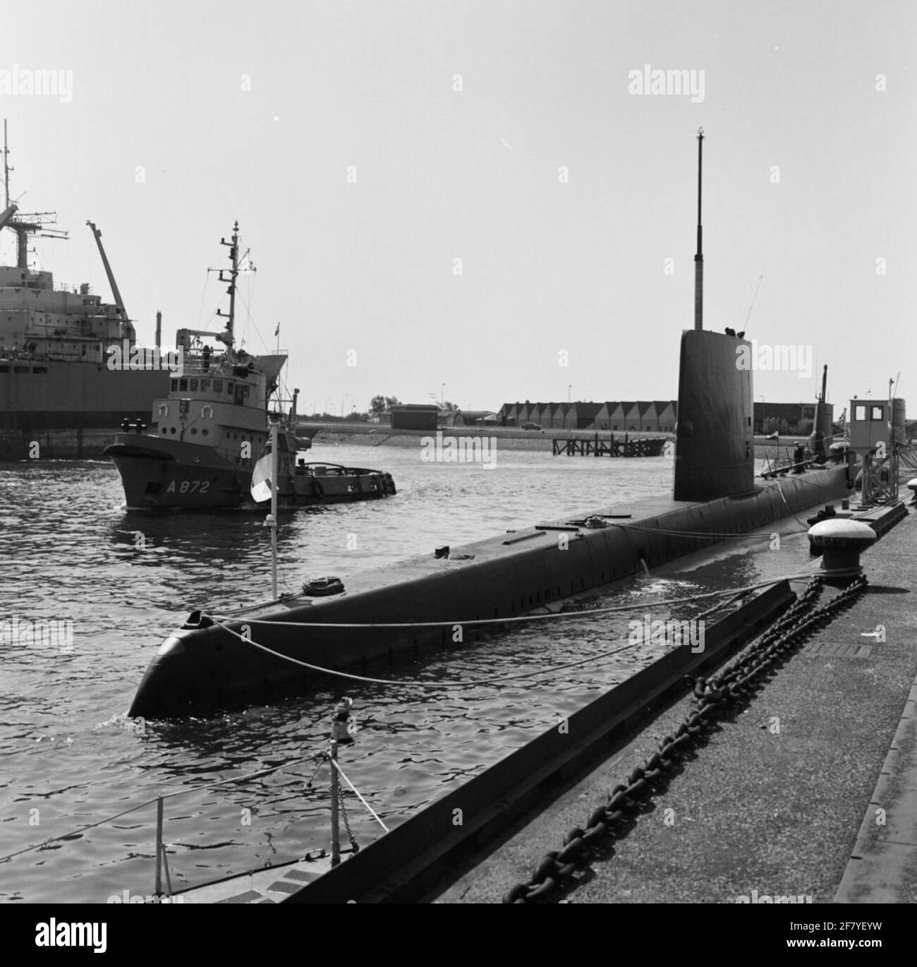 The British submarine HMS Onyx (1966-1990) is moored in the port of Den Helder for a fleet visit. In the background, tugboat Hr.Ms. Westgat (1968-). The Onyx has been moored as a museum ship since 1990 at Historic Warsships, Birkenhead. Stock Photo