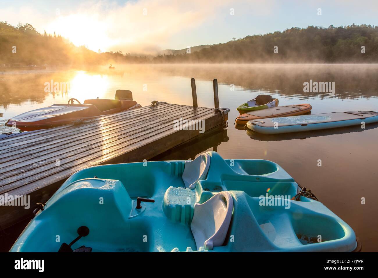 boats and boards floating around a deck in summer on a sunrise Stock Photo
