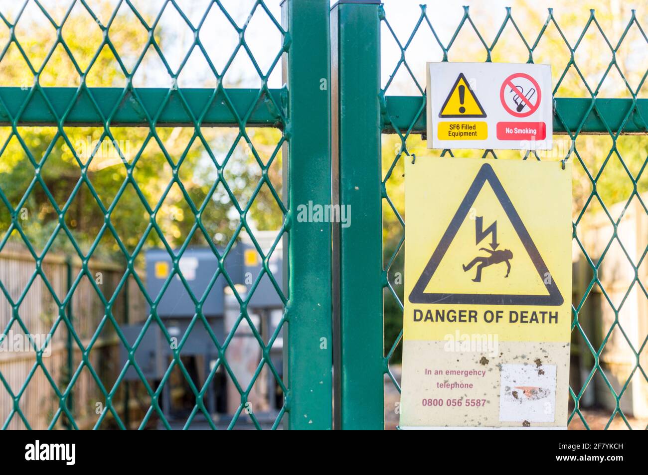 Fence gate to Electric transformer in community with warning signs on gate Stock Photo