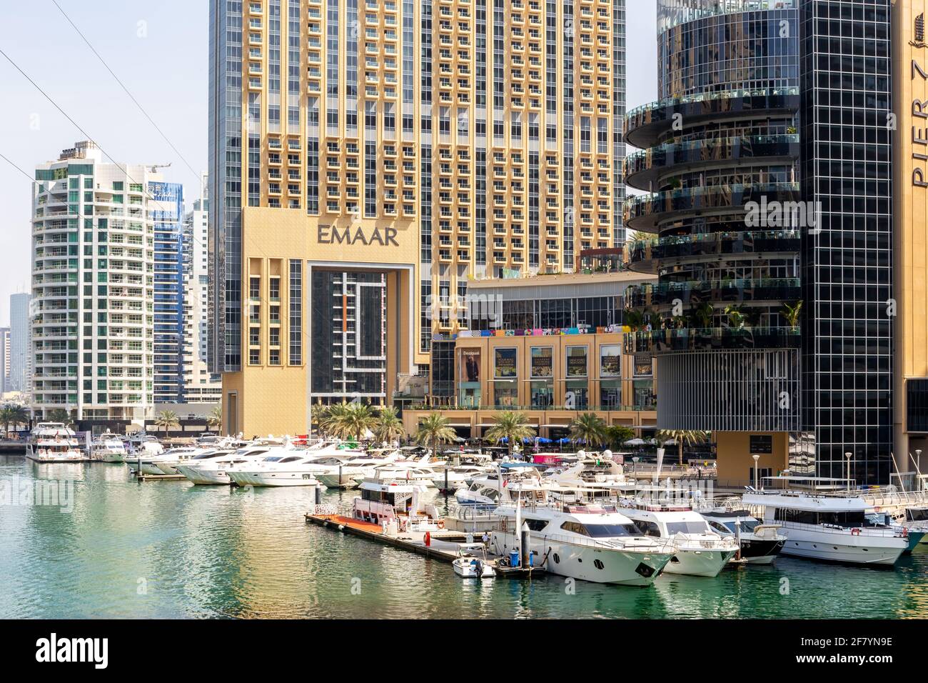 Dubai, UAE, 22.02.2021. Dubai Marina Mall Marine Transport Station on Marina Canal, with Address Dubai Marina building and Dubai skyline. Stock Photo