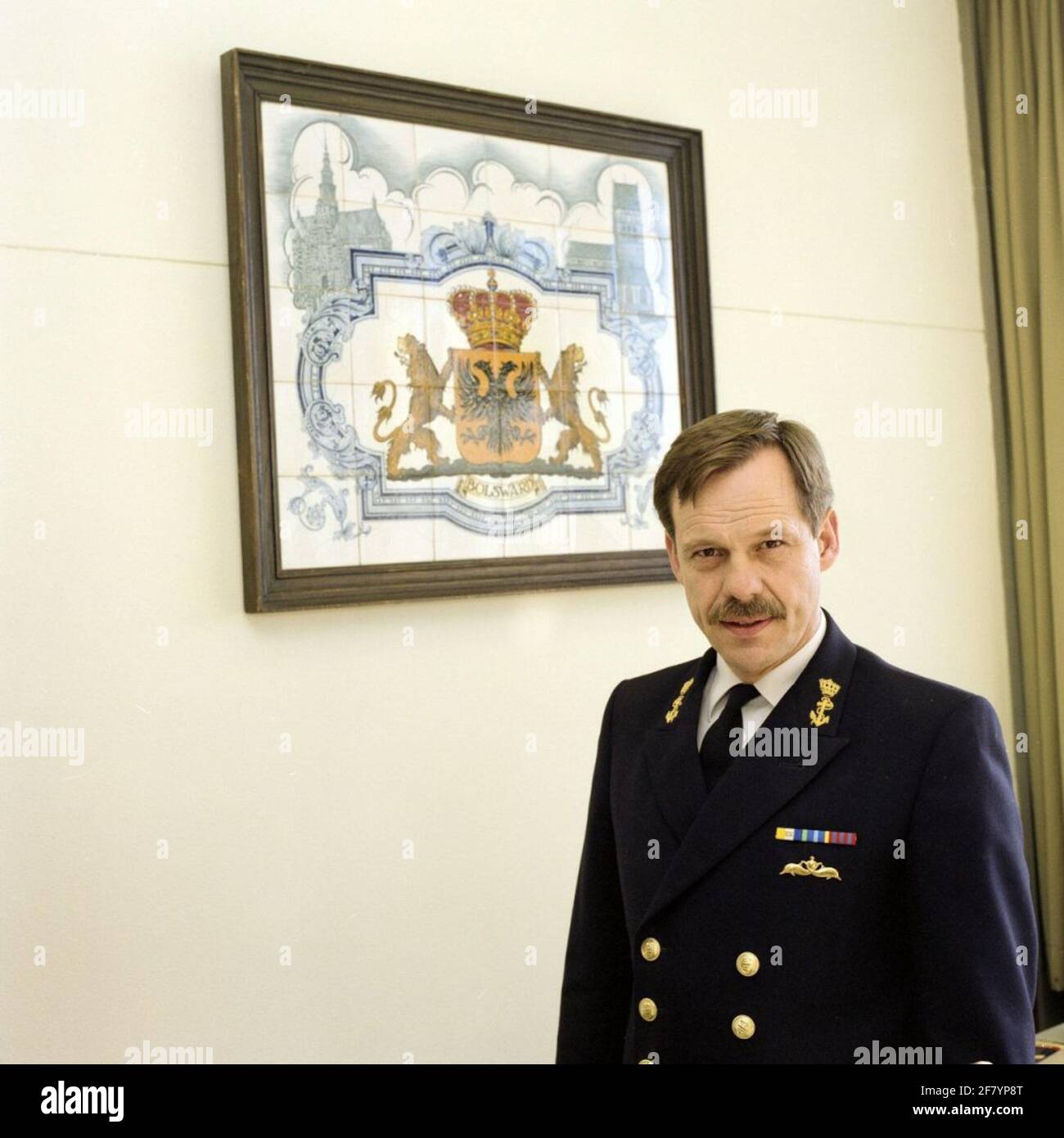 Captain-Ter Sea J.W. The hunter (1943), commander of the operational school (OPS) in his office in March 1990. In the background a tile tableau with the coat of arms of Bolsward, the birthplace of Colonel de Jager. Stock Photo