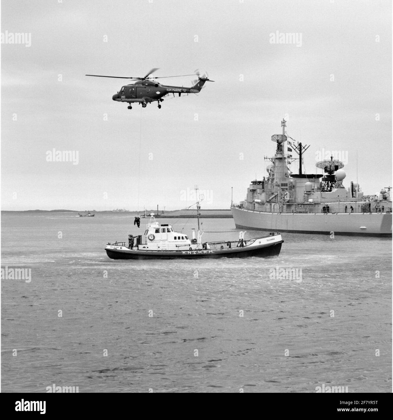 Exercise Person transport From a floating platform by the Westland SH-14D Navy Lynx Helicopter with registration 283 (1981-approx. 2012) in collaboration with the bright rescue boat Suzanna (1968-1998) of the Royal North and South Holland Redding Company (Knzhrm) In May 1990.rechts, L-Fregat Hr.Ms is located. Witte de With (1986-2005). Stock Photo