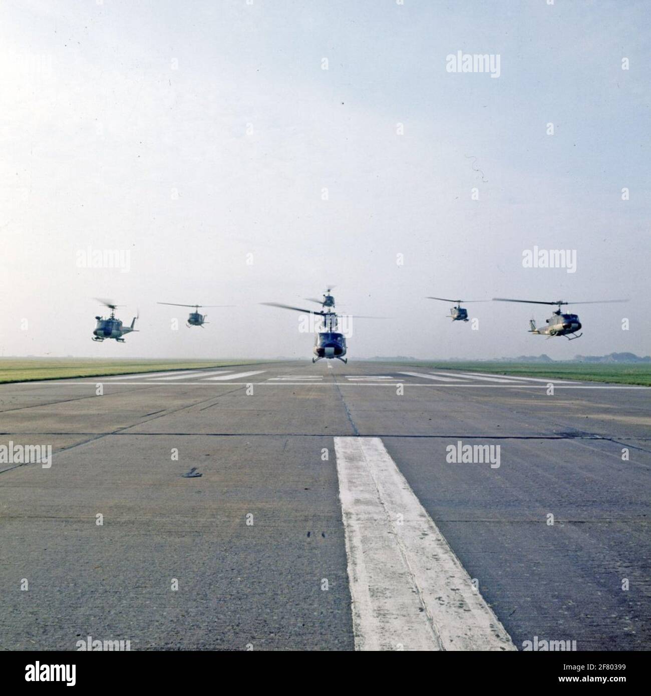 A formation Agusta-Bell 204B (I) UH-1 Air Sea Rescue (ASR) helicopters (1962-1978) above the runway. Stock Photo