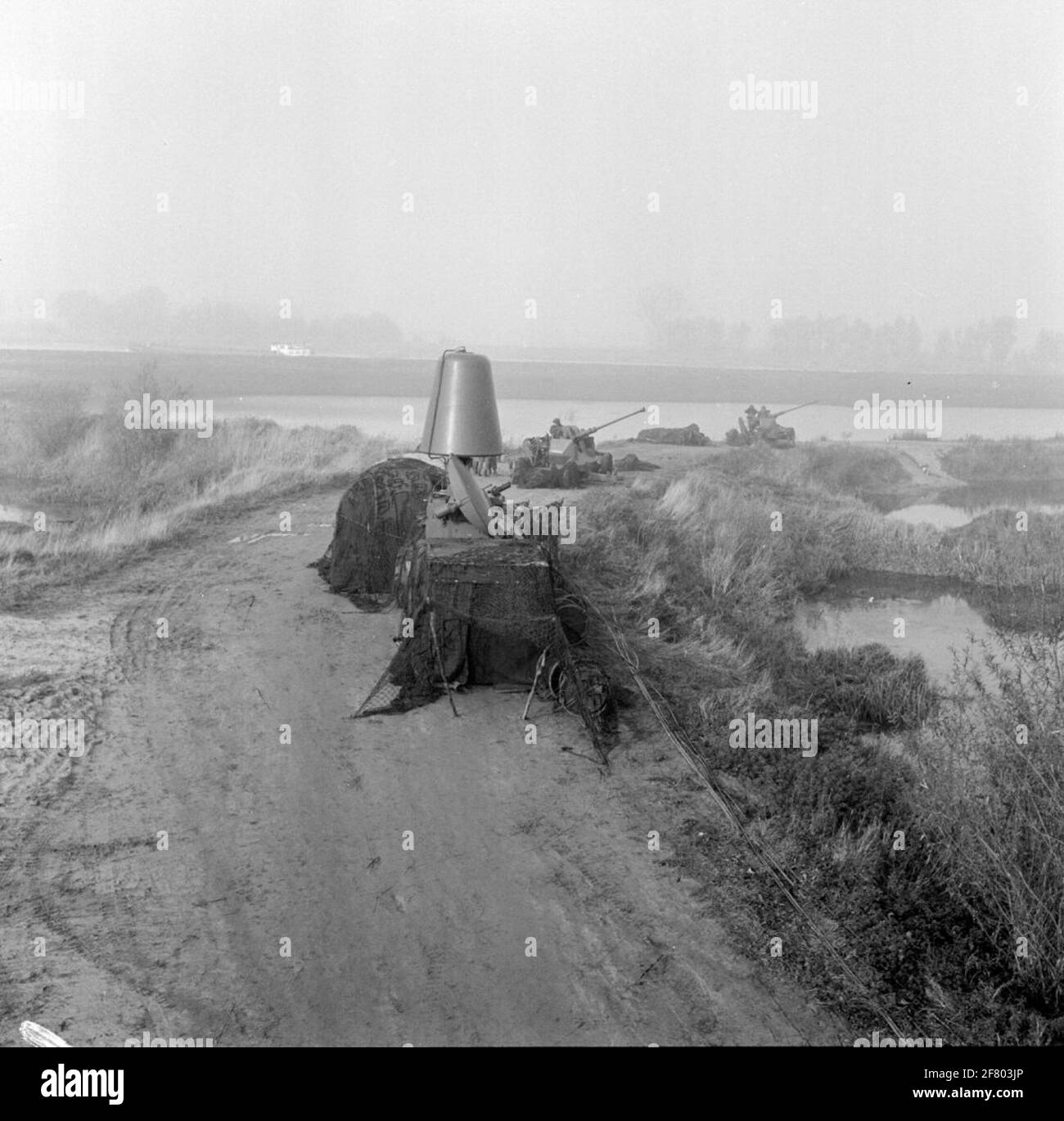Exercise of the A-battery of a light air volume artillery (mobile) from Wezep along the IJssel between Zwolle and Deventer (Wijhe-Olst). Position in the floodplains. In the foreground an HSA (Dutch signal devices) L4 / 5 (KL / MSS 3012) radar fire ride device to which three pieces were coupled. In the background two 40L70 fire premises in the position. Stock Photo