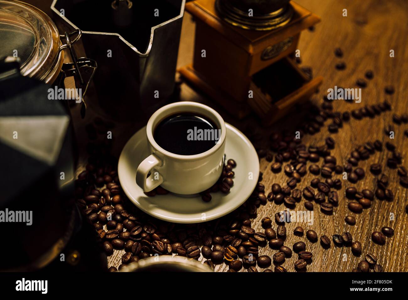 https://c8.alamy.com/comp/2F805DK/coffee-stuff-a-white-cup-with-black-coffee-italian-coffee-maker-moka-a-mill-and-grains-over-a-wooden-table-vintage-rustic-style-2F805DK.jpg