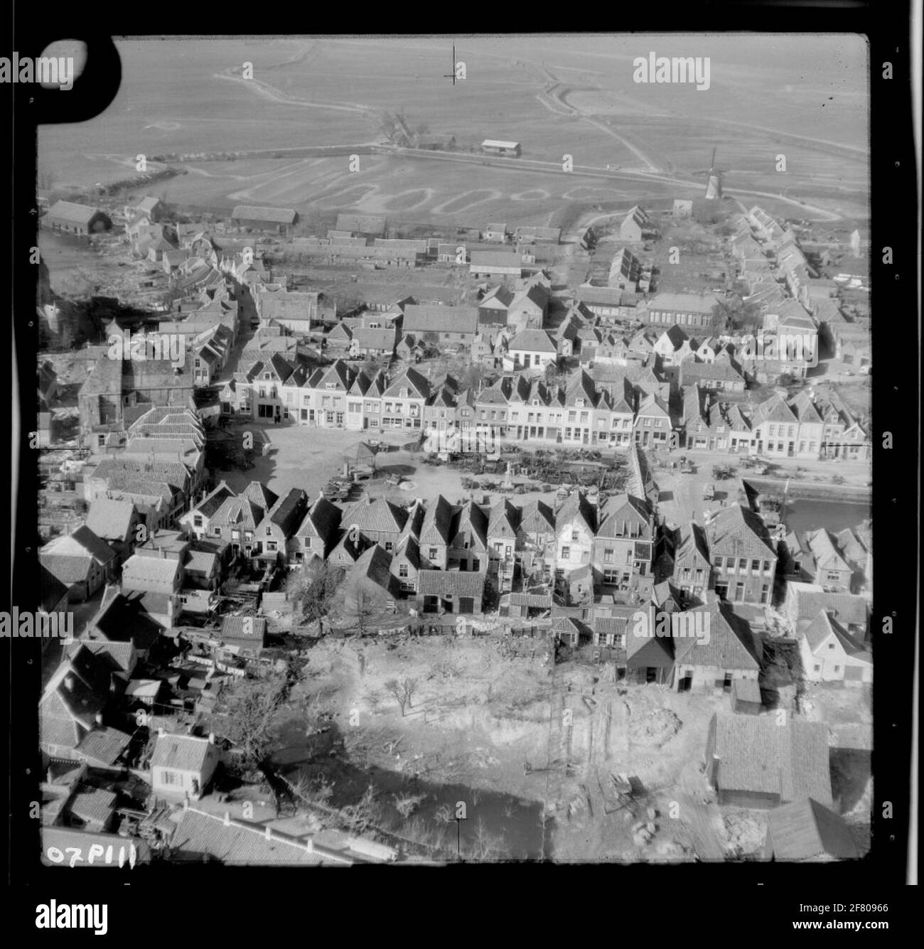 Water shortage disaster 1953. Air photo of Brouwershaven and an overview of the area affected by the disaster. Central left the Grote or Sint Nicolaaskerk on the church square and the right above the corner of the rooster at the north. In the middle of the market the statue of Jacob Cats and the music kiosk. Stock Photo