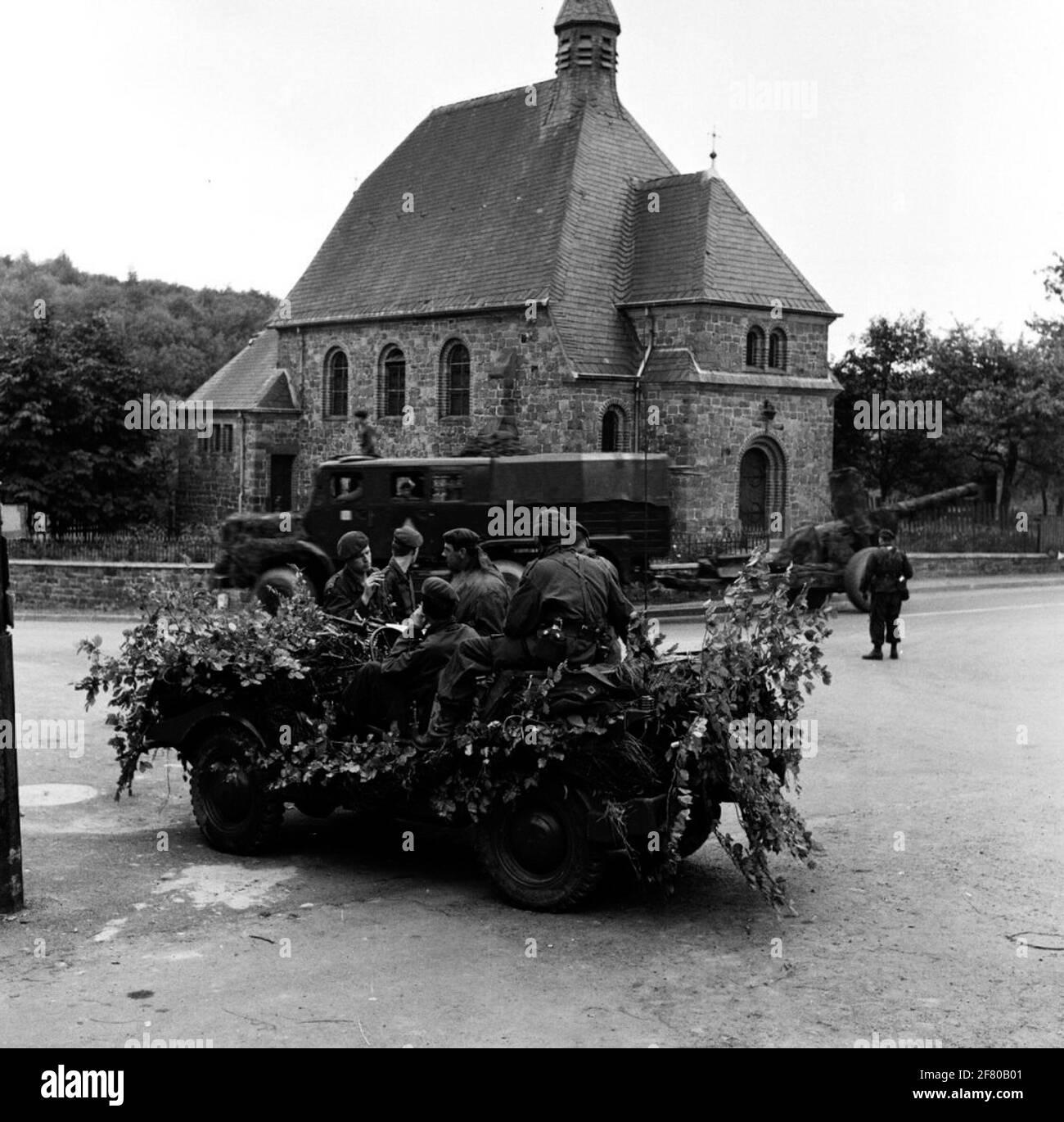 A number of soldiers from the royal land power at and in a heavily  camouflaged DKW Munga at the Kapelle Mariä Heimsuchung in Ikehausen during  Eternal Triangle exercise. A Leyland Martian FV1103