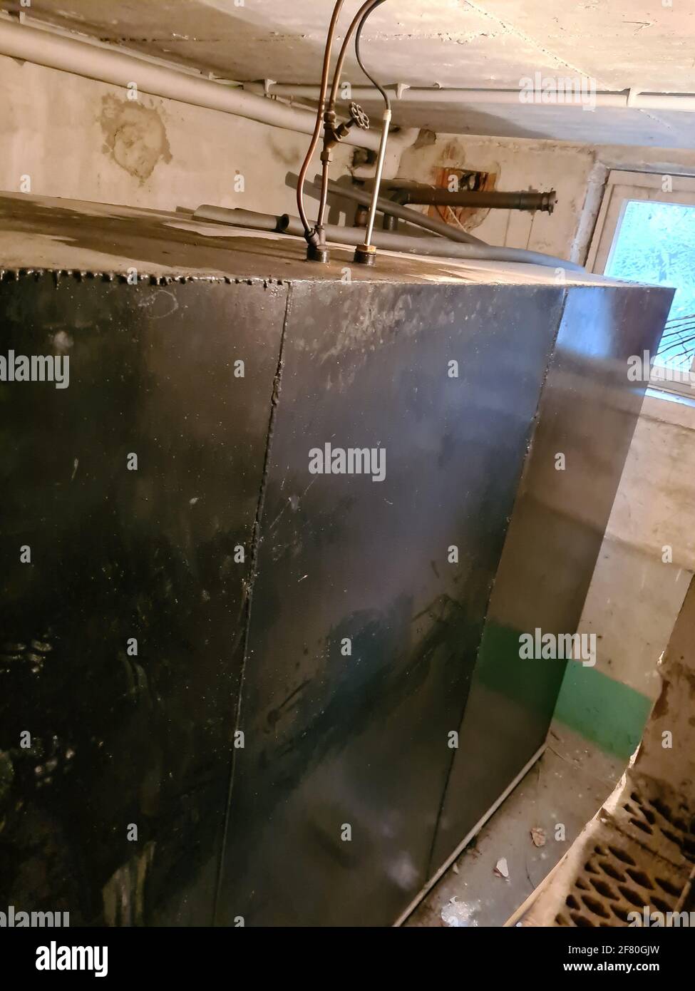 Old heating oil tank in dingy dank basement Stock Photo Alamy