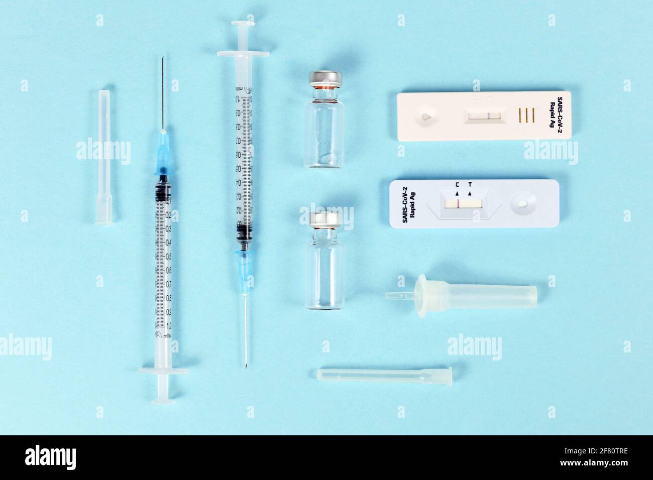 Rapid antigen test and vaccine vials with syringes. Tools to fight Corona Virus pandemic. Stock Photo