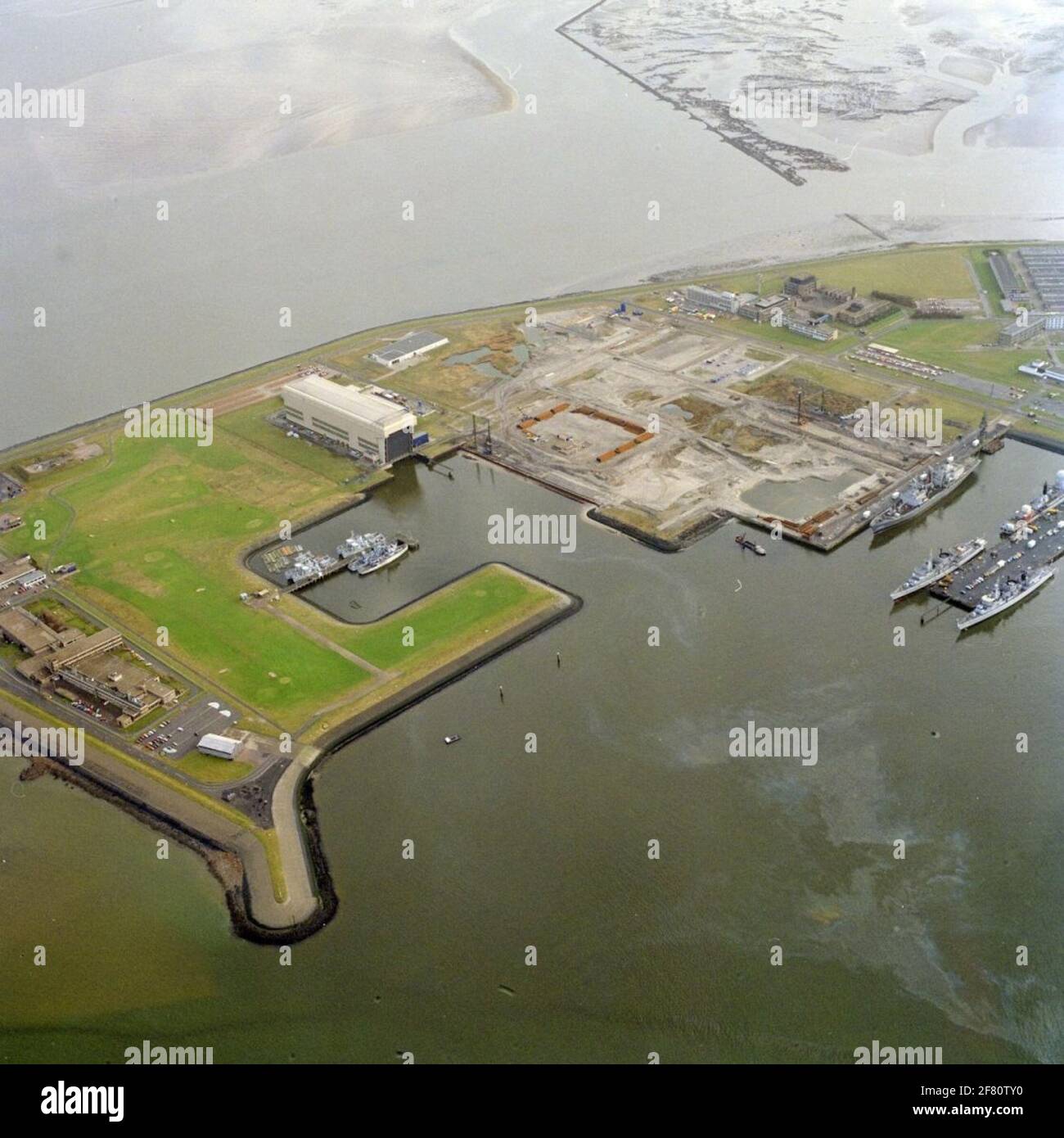 Aerial view of the eastern part of the new port, the new Rijkswerf, NBCD school and the pyromaniac. In the site basin, preserved mine sweeps of the mining service department lie. The supply vessel on scaffolding 24 is Hr.Ms. Poolster (1964-1994). Hr.Ms lie to jetty 23. Abraham Crijnsen (1983-1997), where the 40 mm machine guner on the hangar is replaced by Goalkeeper-Snelvervuurkanon, and Hr.Ms. De Ruyter (1976-2001) also in maintenance. Hr.Ms is located on scaffolding 22. Piet Hein (1981-1995). Stock Photo