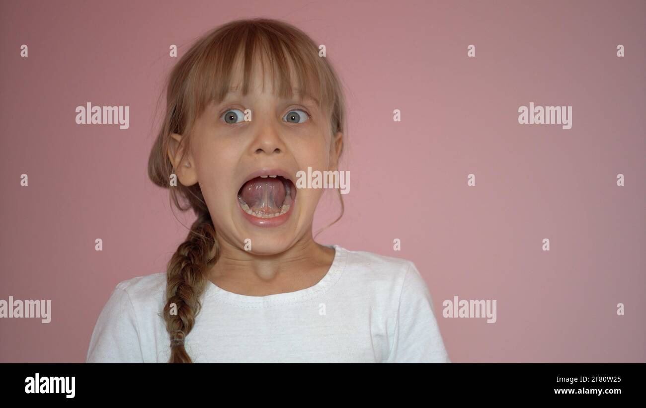 Surprised little girl. Isolate on pink background Stock Photo - Alamy