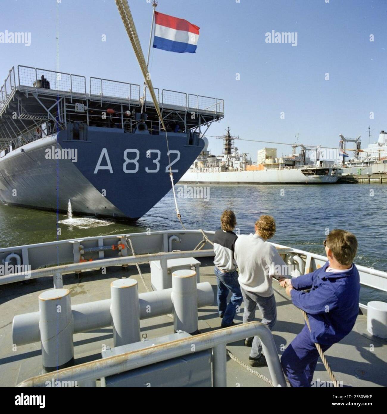 Various recording of the small vessels service (kvd), where the marine trail boats also fall under. A tugboat is working on the multi-resistant ship Hr.Ms. Zuiderkruis (A 832, 1975-2012) in December 1989. In the background the GW frigate Hr.Ms. De Ruyter (F 808, 1976-2001). Stock Photo