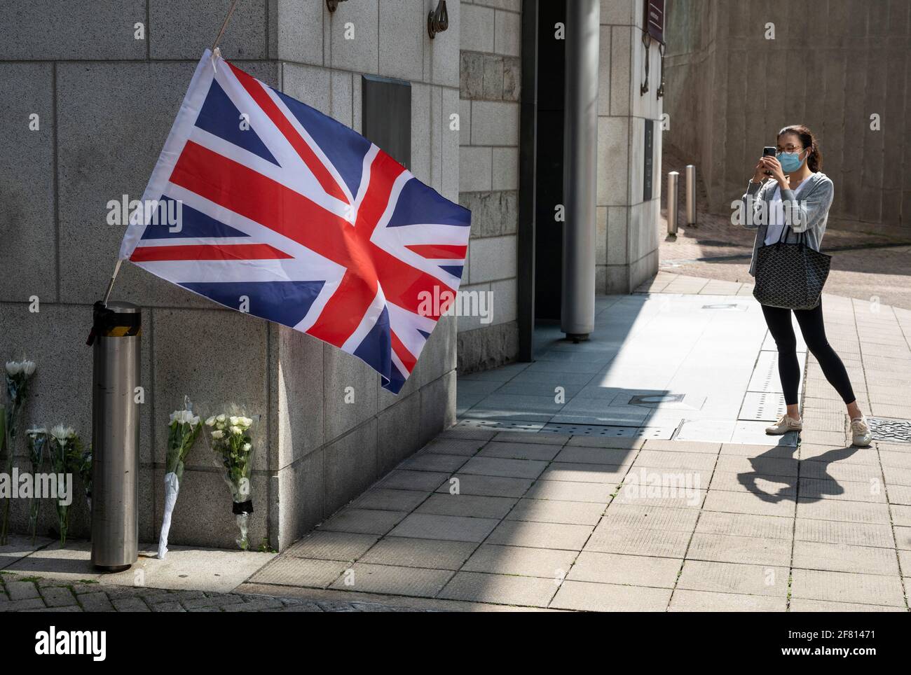 A woman takes a photo of the vigil outside the embassy British
