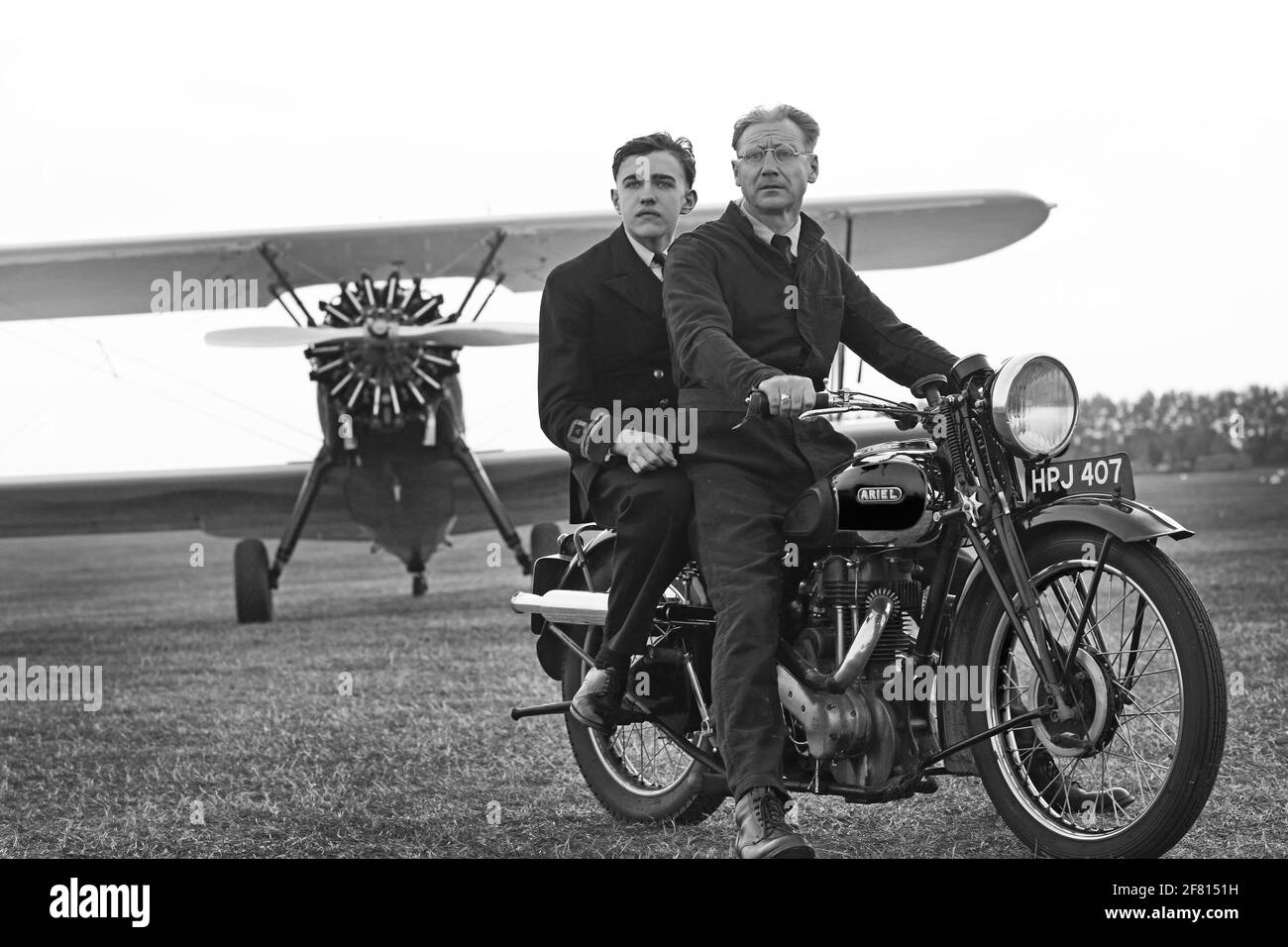 Goodwood revival, two man sitting on Ariel classic motorbike with vintage plane in the background , West Sussex, UK Stock Photo