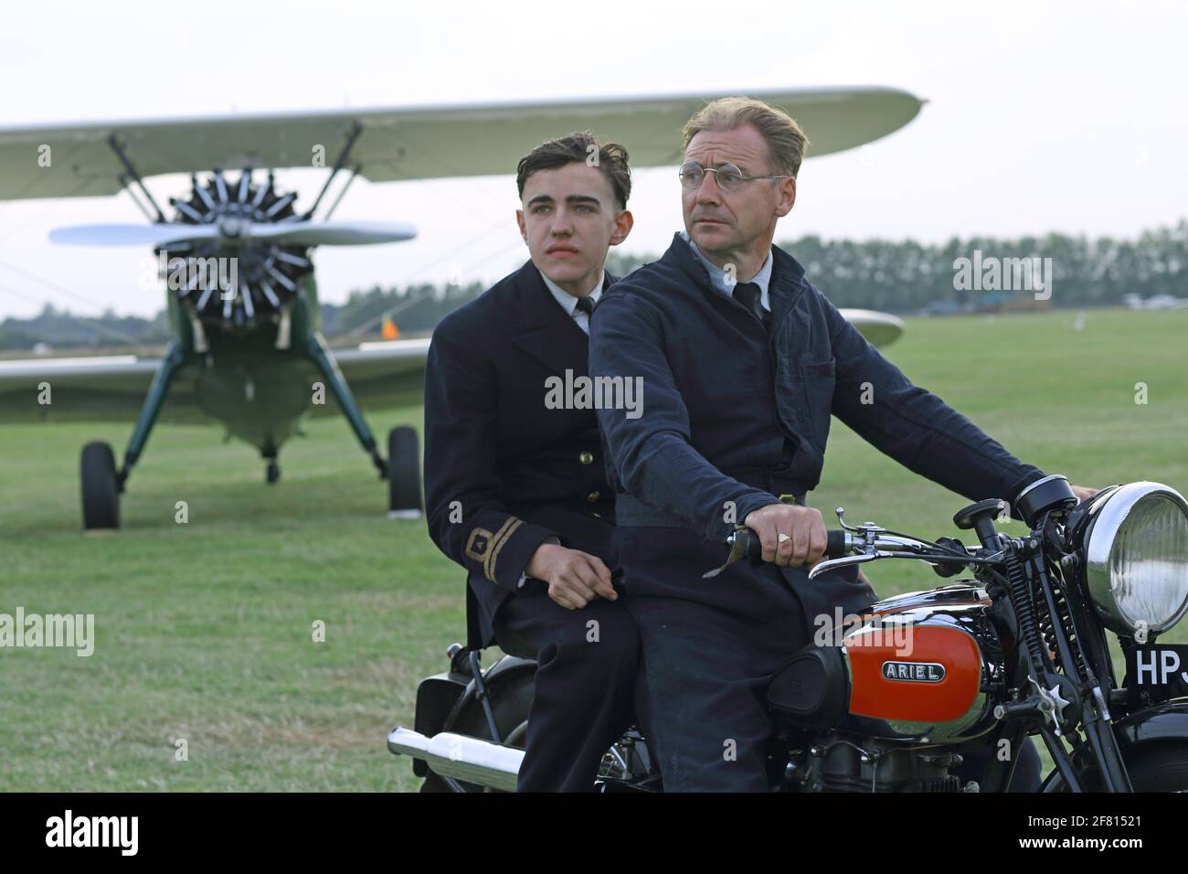 Goodwood revival, two man sitting on Ariel classic motorbike with vintage plane in the background , West Sussex, UK Stock Photo