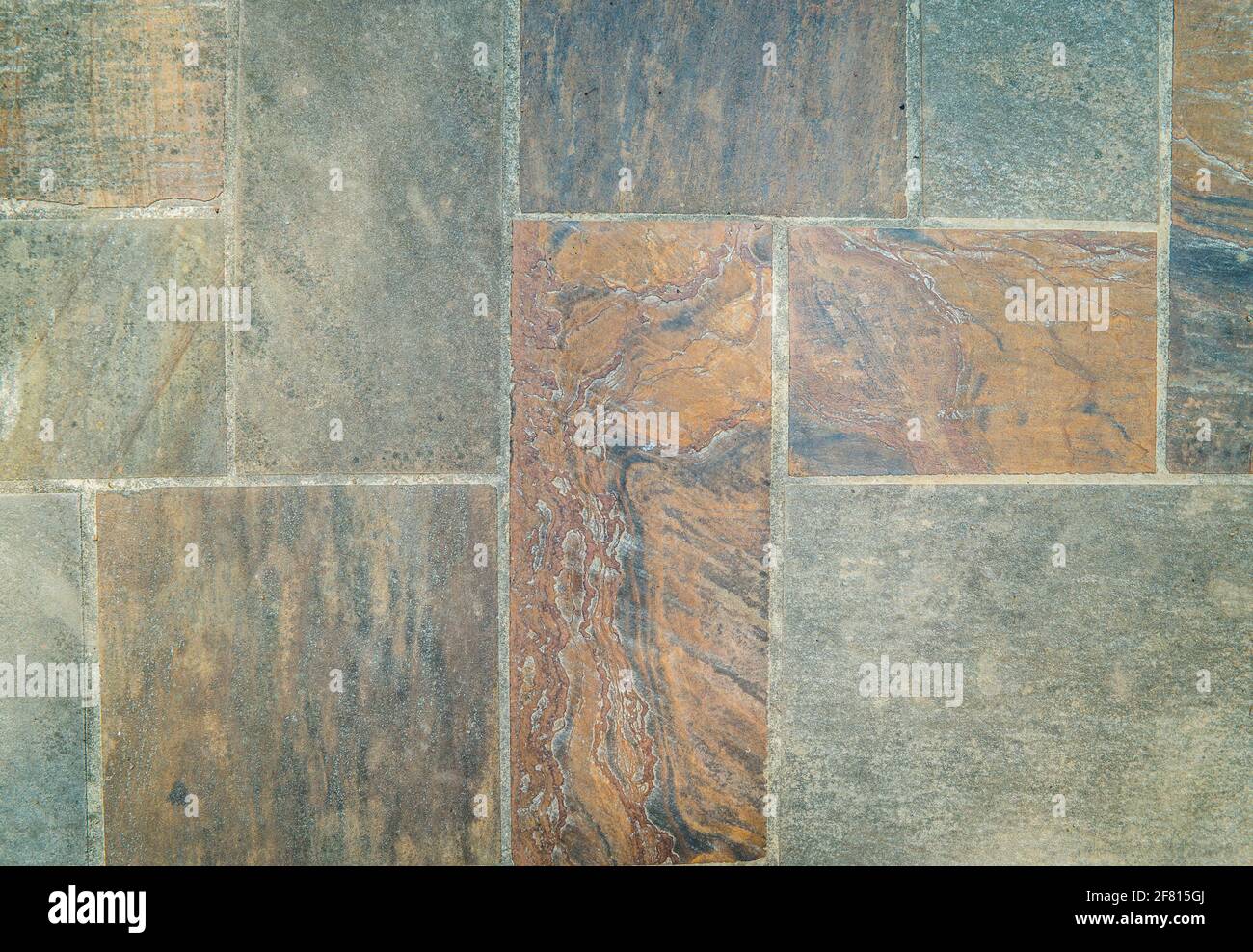 Looking down on old colorful cut rock and stone set in cement in ...