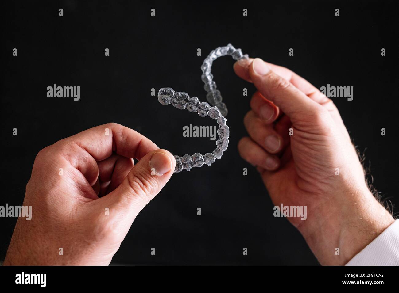 Doctor hands holding a transparent dental aligner Stock Photo - Alamy