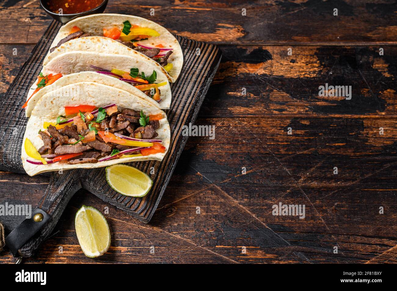 Tacos shells with pork meat, onion, tomato, sweet pepper and salsa