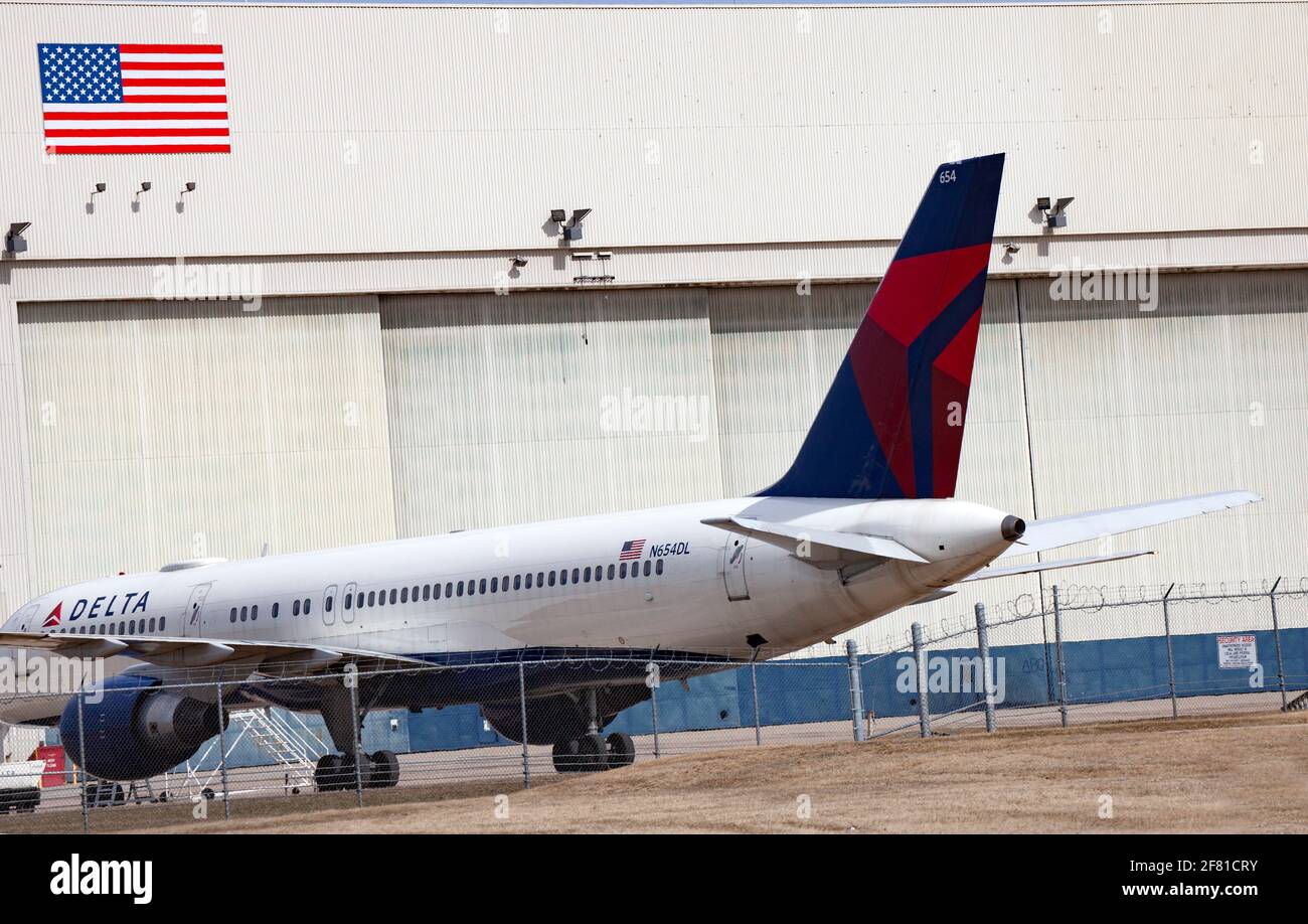 Delta Airplane parked with hangar and American flag in the background at the Minneapolis St Paul International Airport. Minneapolis Minnesota MN USA Stock Photo