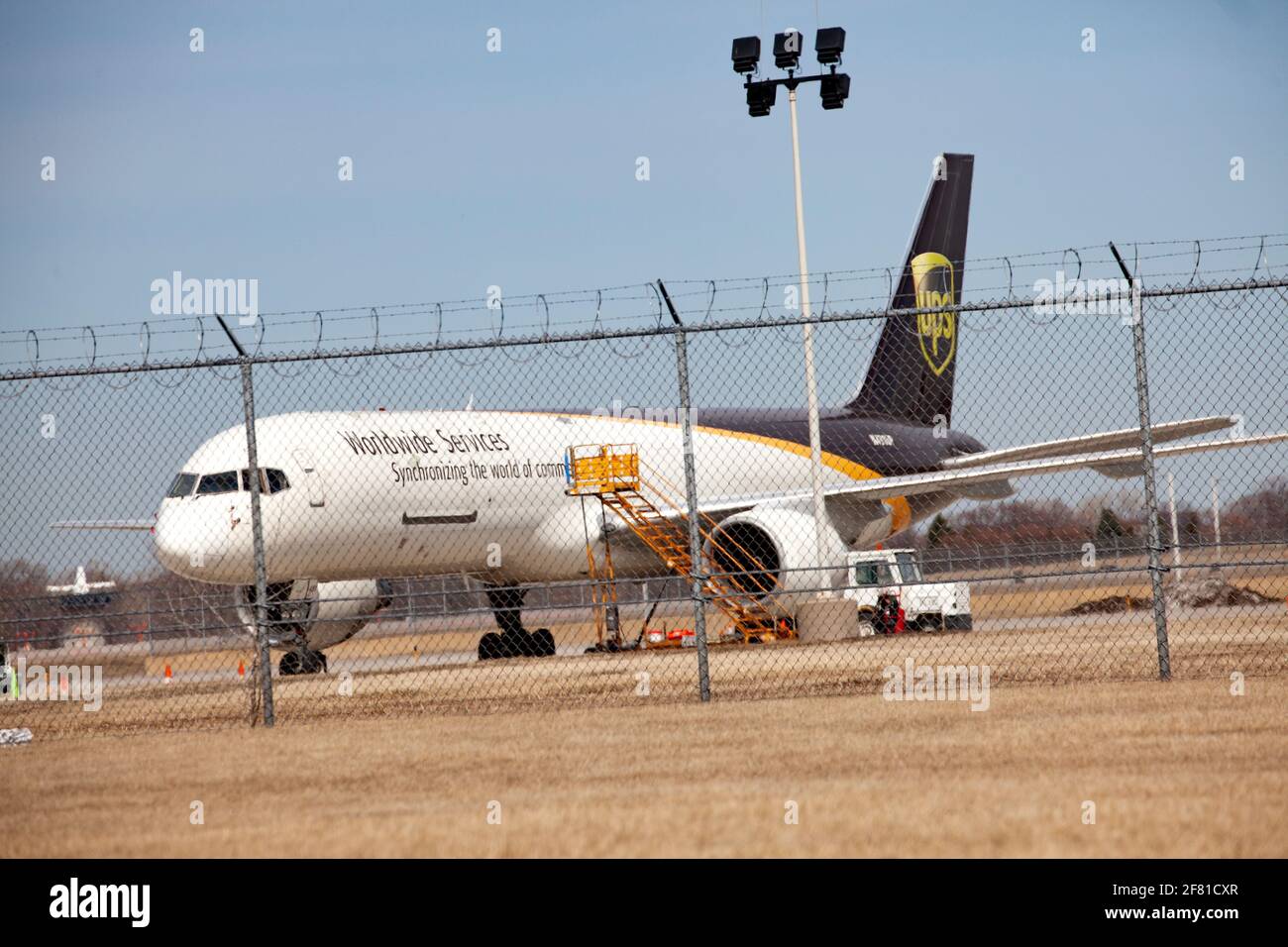 UPS Airplane parked at Minneapolis St Paul International Airport behind chain linked fence topped with concertina wire.  Minneapolis Minnesota MN USA Stock Photo