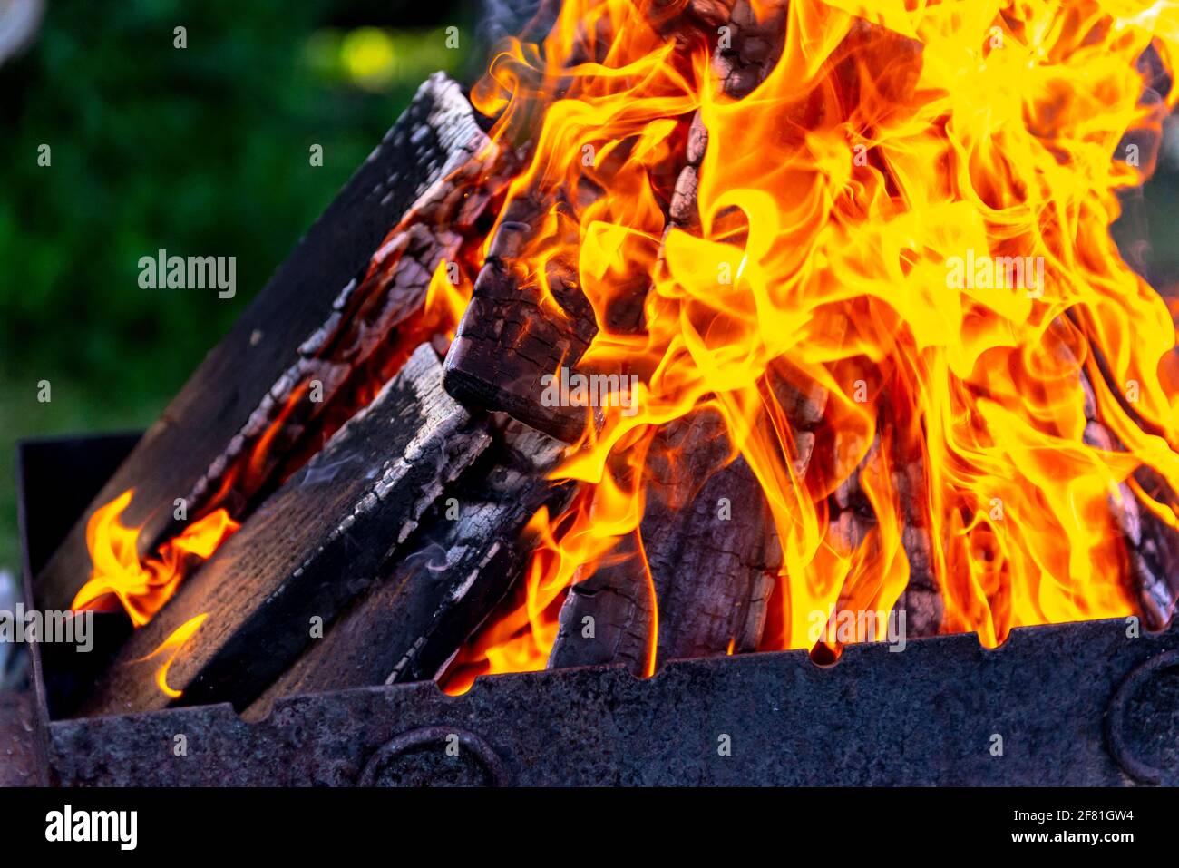 A large fire made of planks. Firewood in a bright flame. Firewood burns