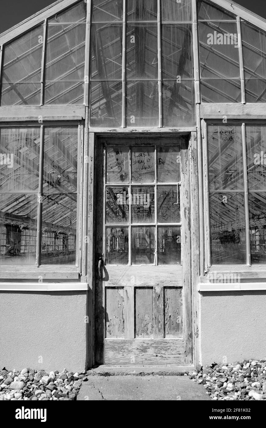 Black & white shot of a very worn front door of an empty greenhouse at the Central Experimental Farm, Ottawa, Ontario, Canada. Stock Photo